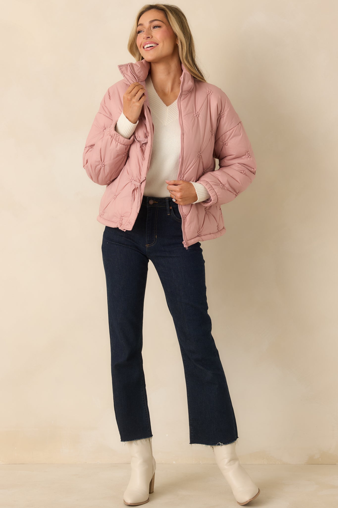 Blush pink quilted puffer jacket with allover floral-inspired stitching, stand collar, and full front zipper closure.