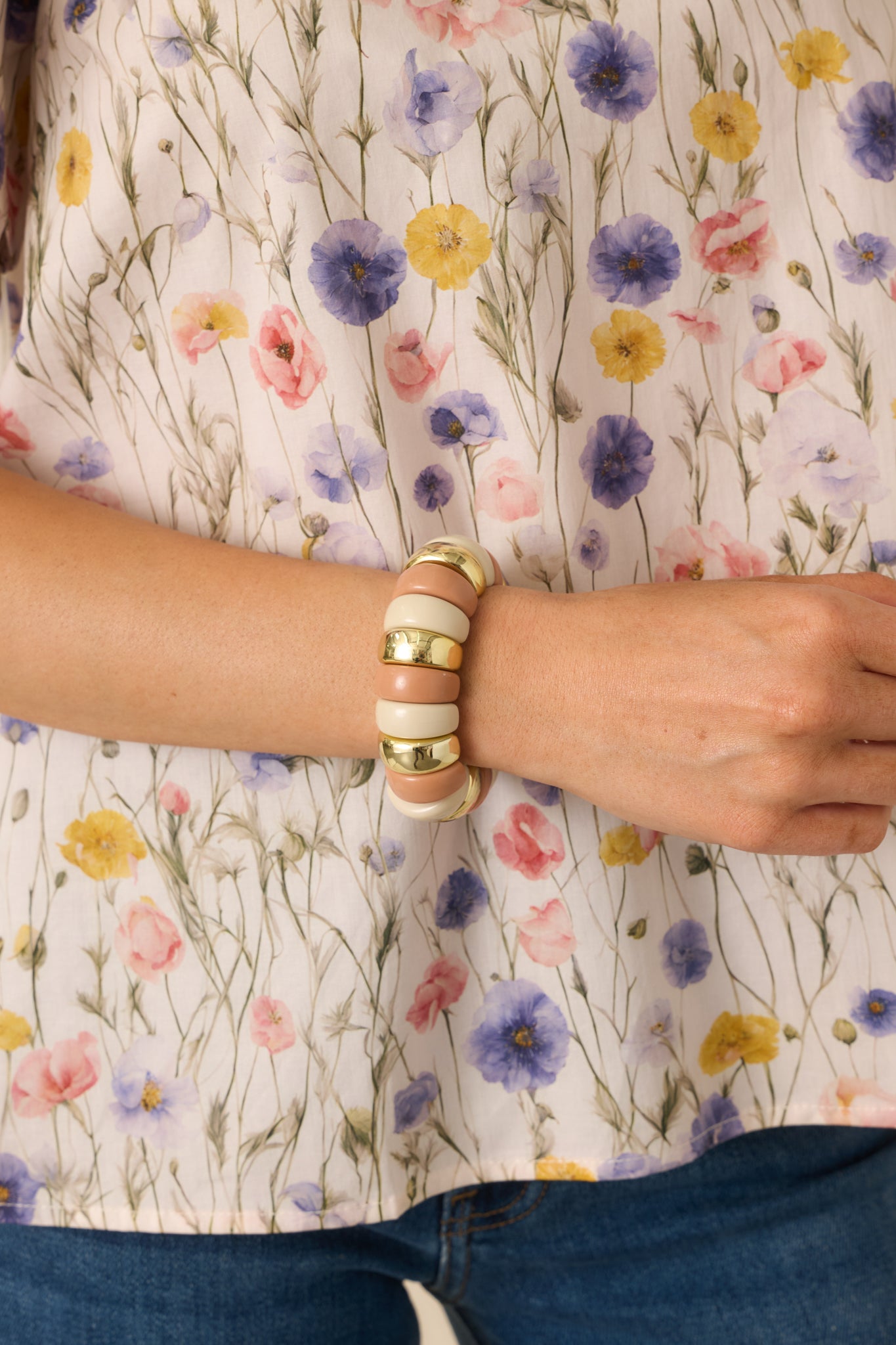 Cropped view of blush pink statement bracelet featuring sculptural beads in muted pink and ivory with polished gold accents.