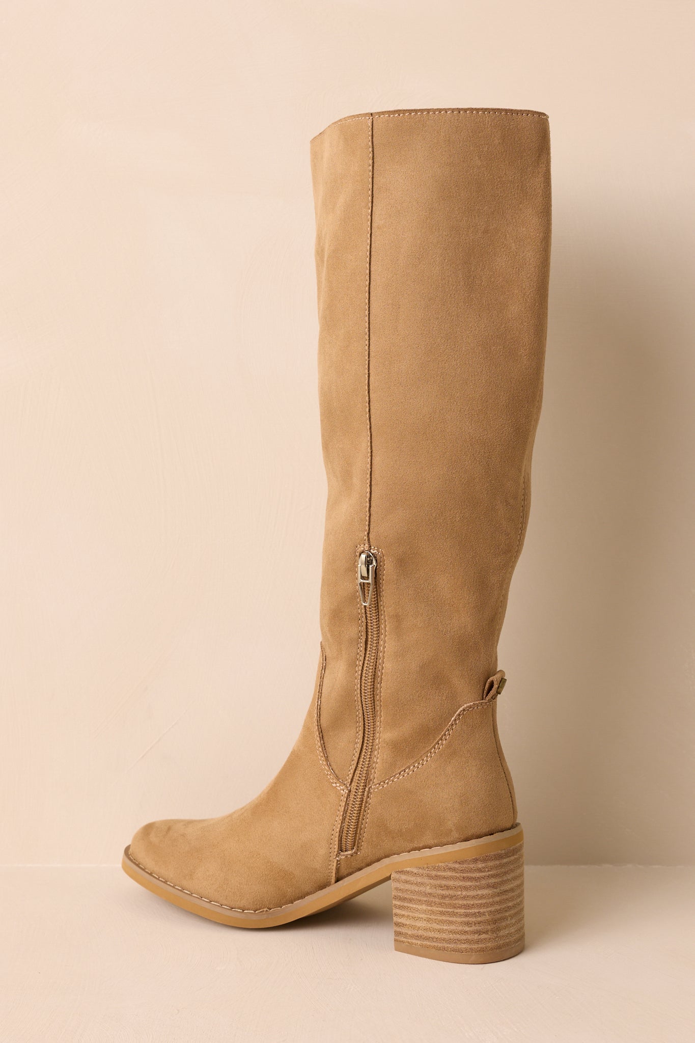 An angled back view of the boots capturing the block heel and inner zipper.