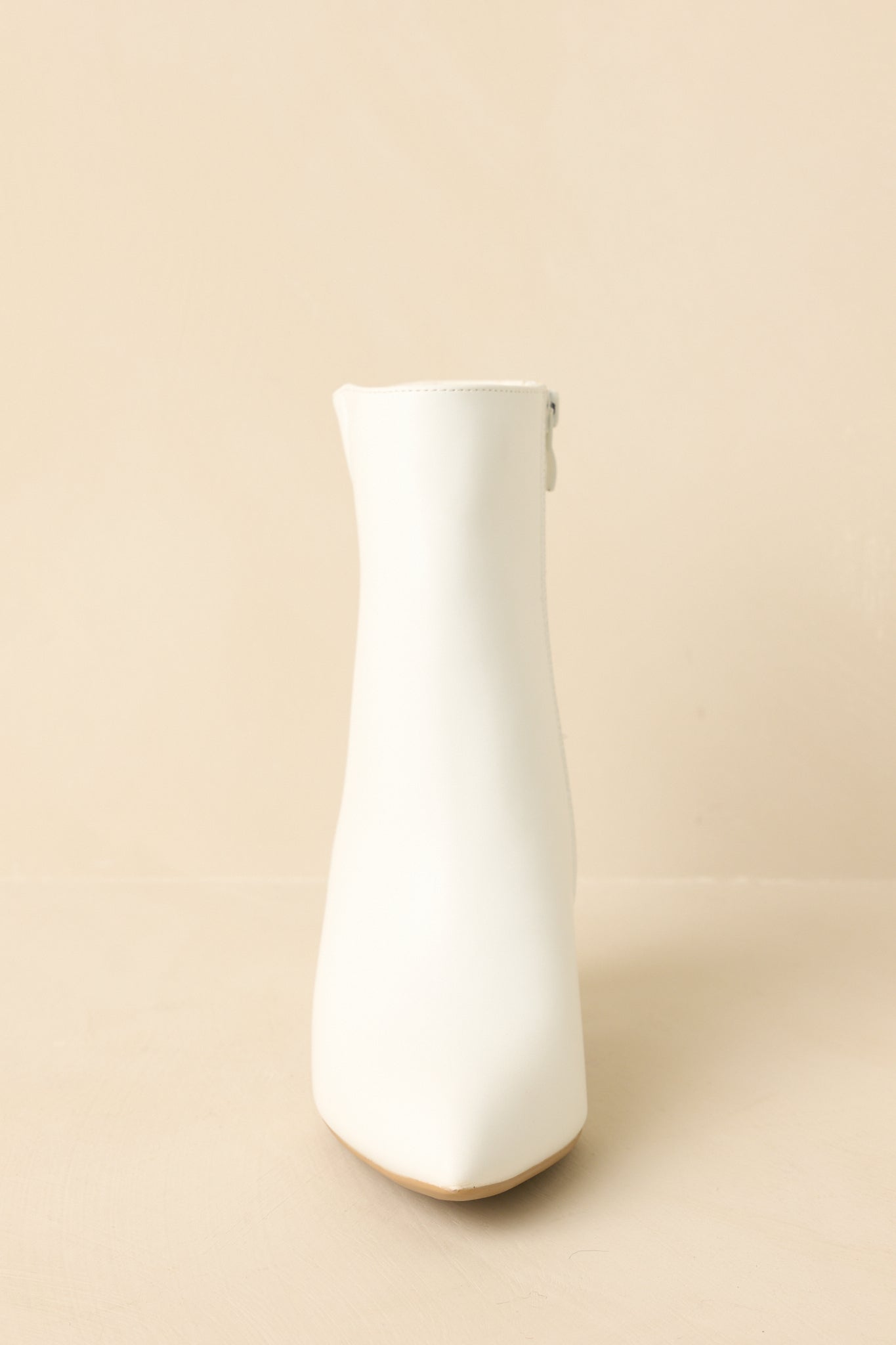 Boots displayed to show the smooth upper, pointed toe, and clean silhouette.