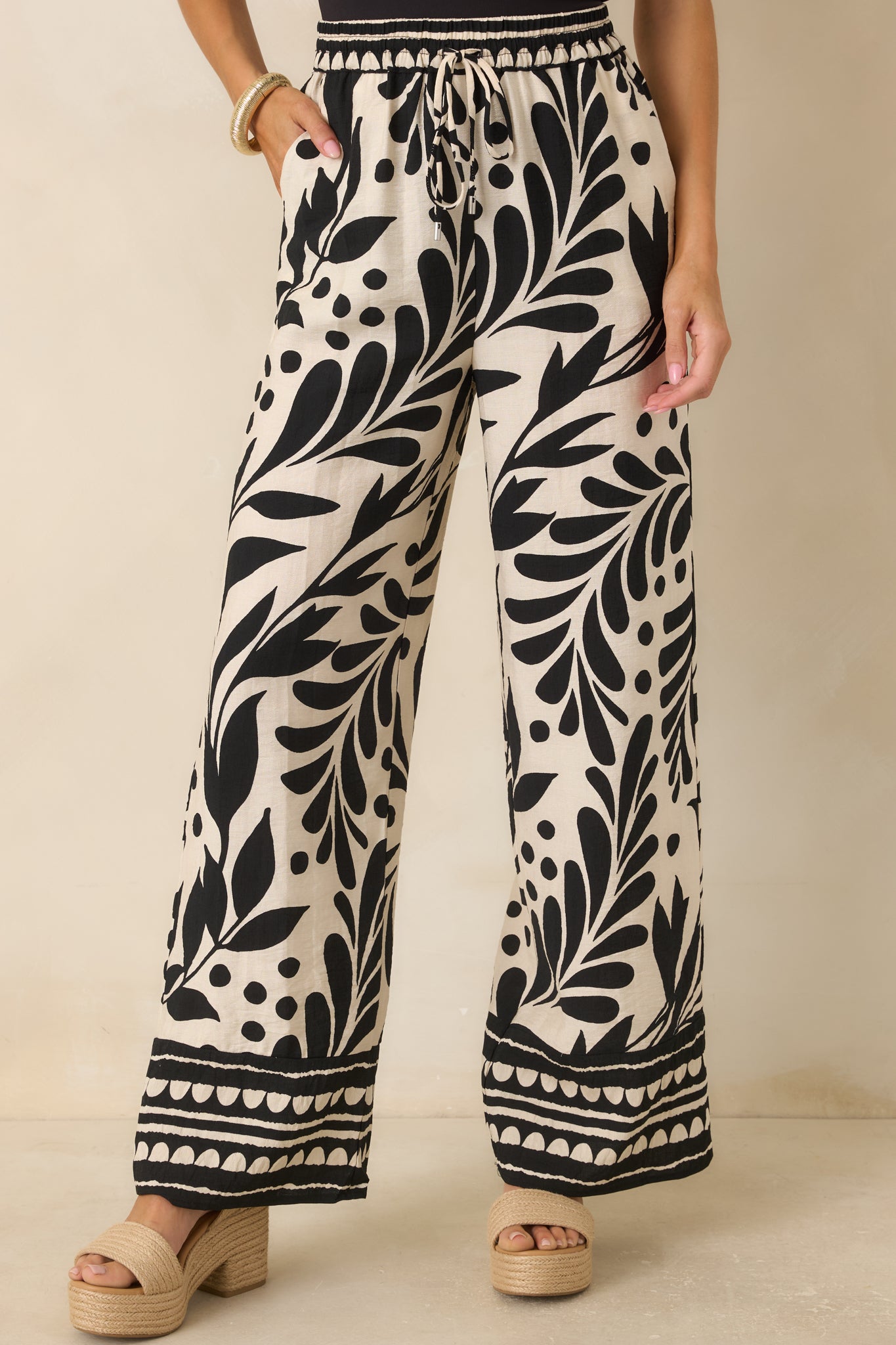 Front cropped view emphasizing the oversized botanical print and coordinating border trim at the hem of the pants.
