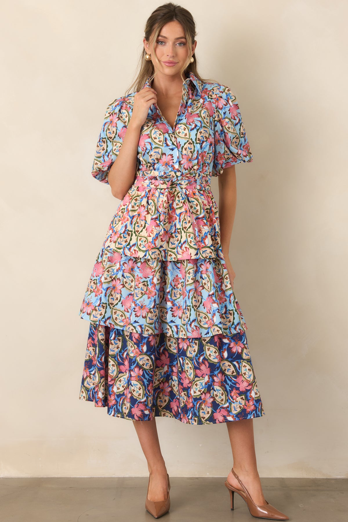 Colorful botanical dress with a defined waist and flowing layered skirt in blue, ivory, pink, and green.