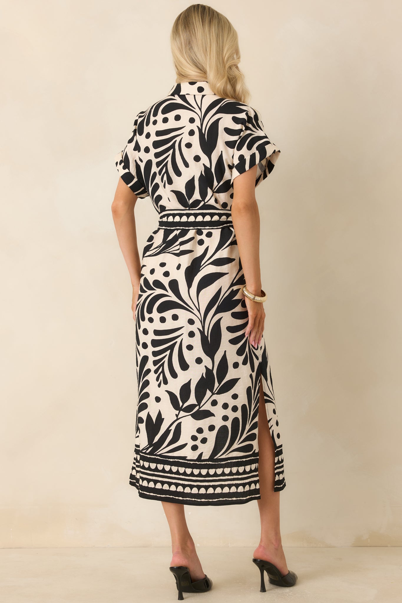 Rear view of the botanical print midi dress featuring relaxed dolman sleeves, cuffed hems, and a flowing silhouette.