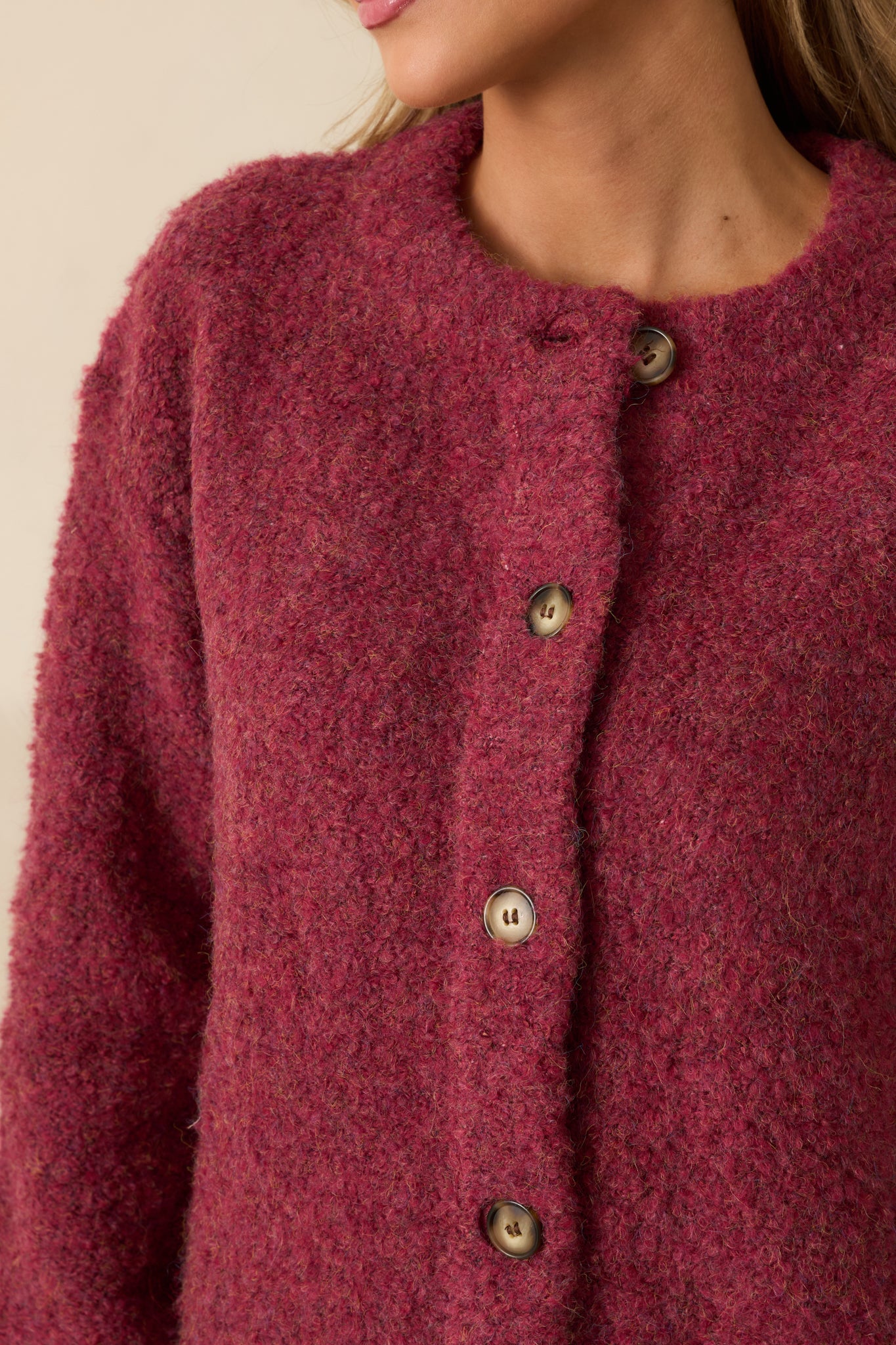 Detailed look at the boucle knit and button closure, capturing the cardigan’s plush texture and craftsmanship.