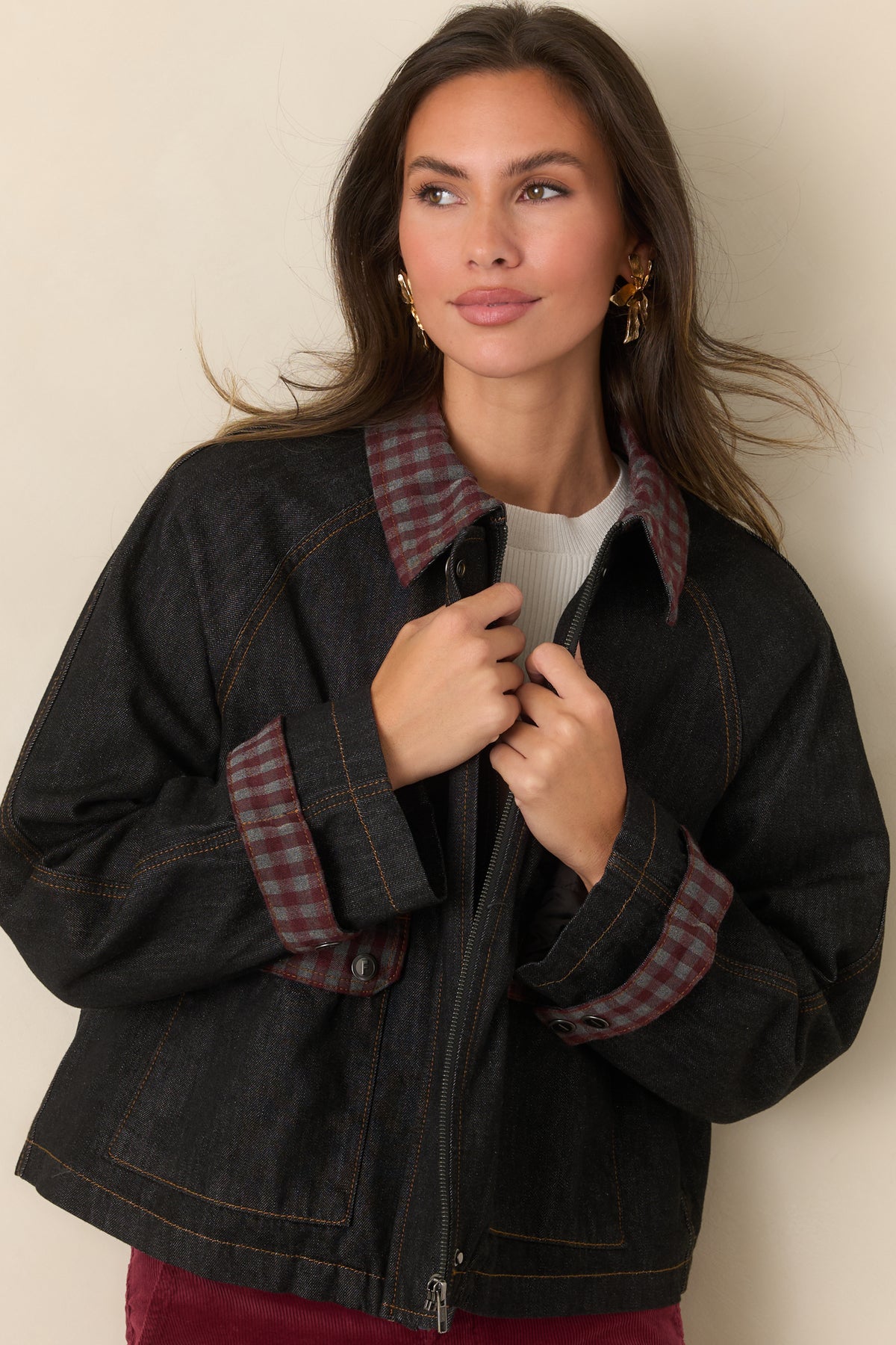 Boxy denim jacket highlighting the contrast stitching around its oversized front pockets and gingham accents.