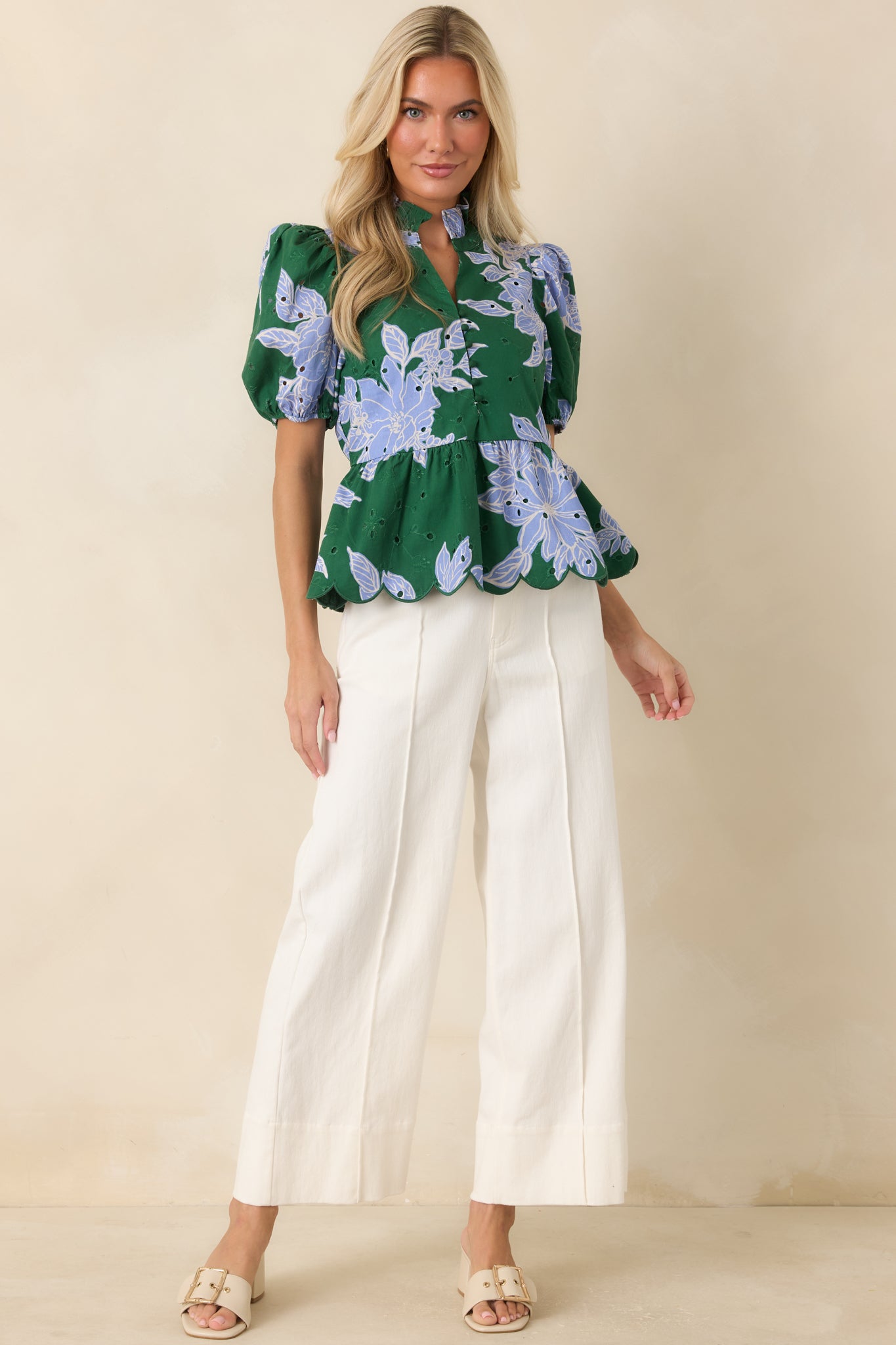 Breathable cotton floral top featuring a ruffle neckline, embroidered eyelet detailing, puff sleeves, and an elasticized waist.