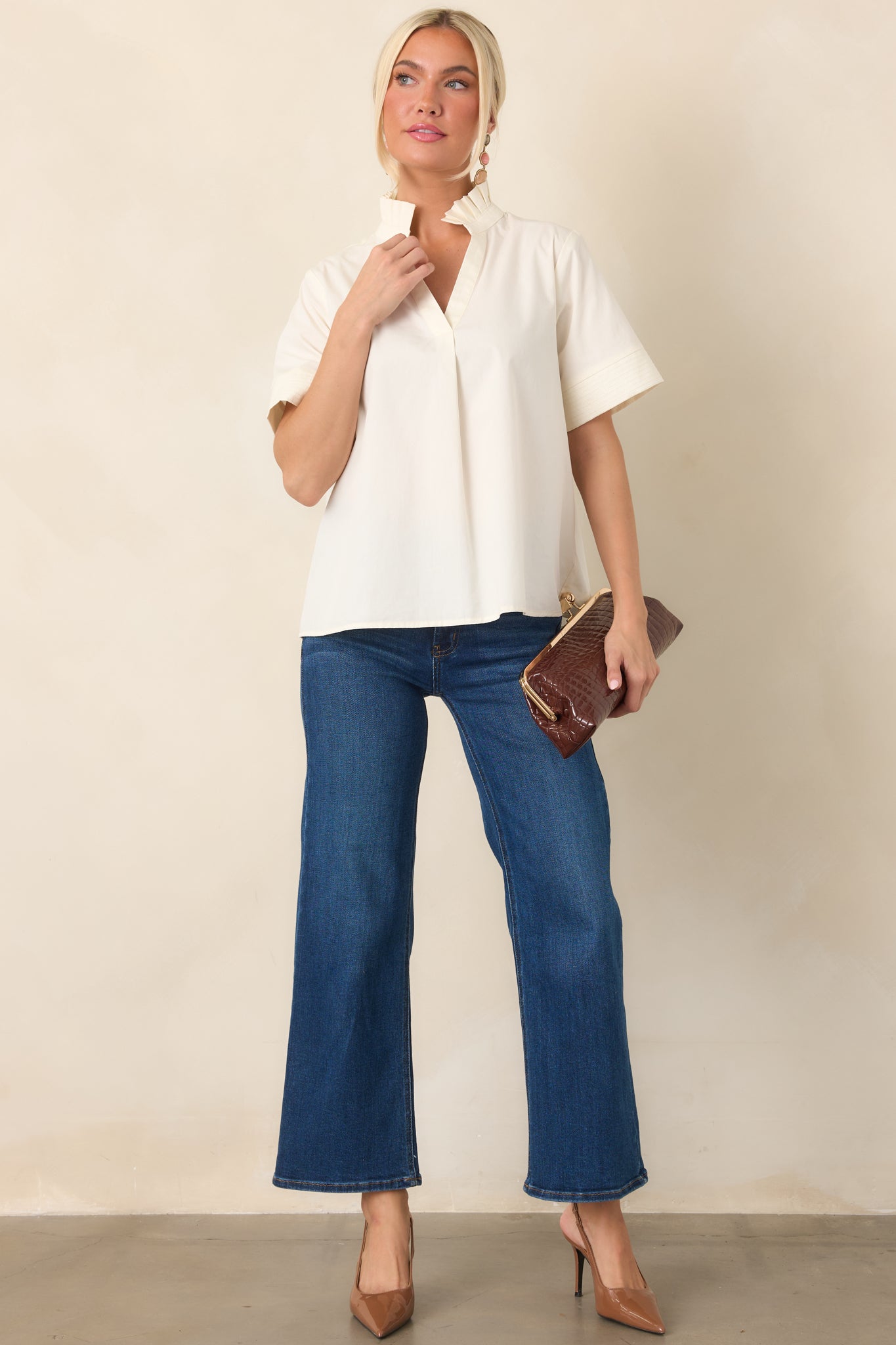 Breathable cotton top showcasing its softly structured ruffle neckline, open split neck, short sleeves, and neatly finished cuff details.