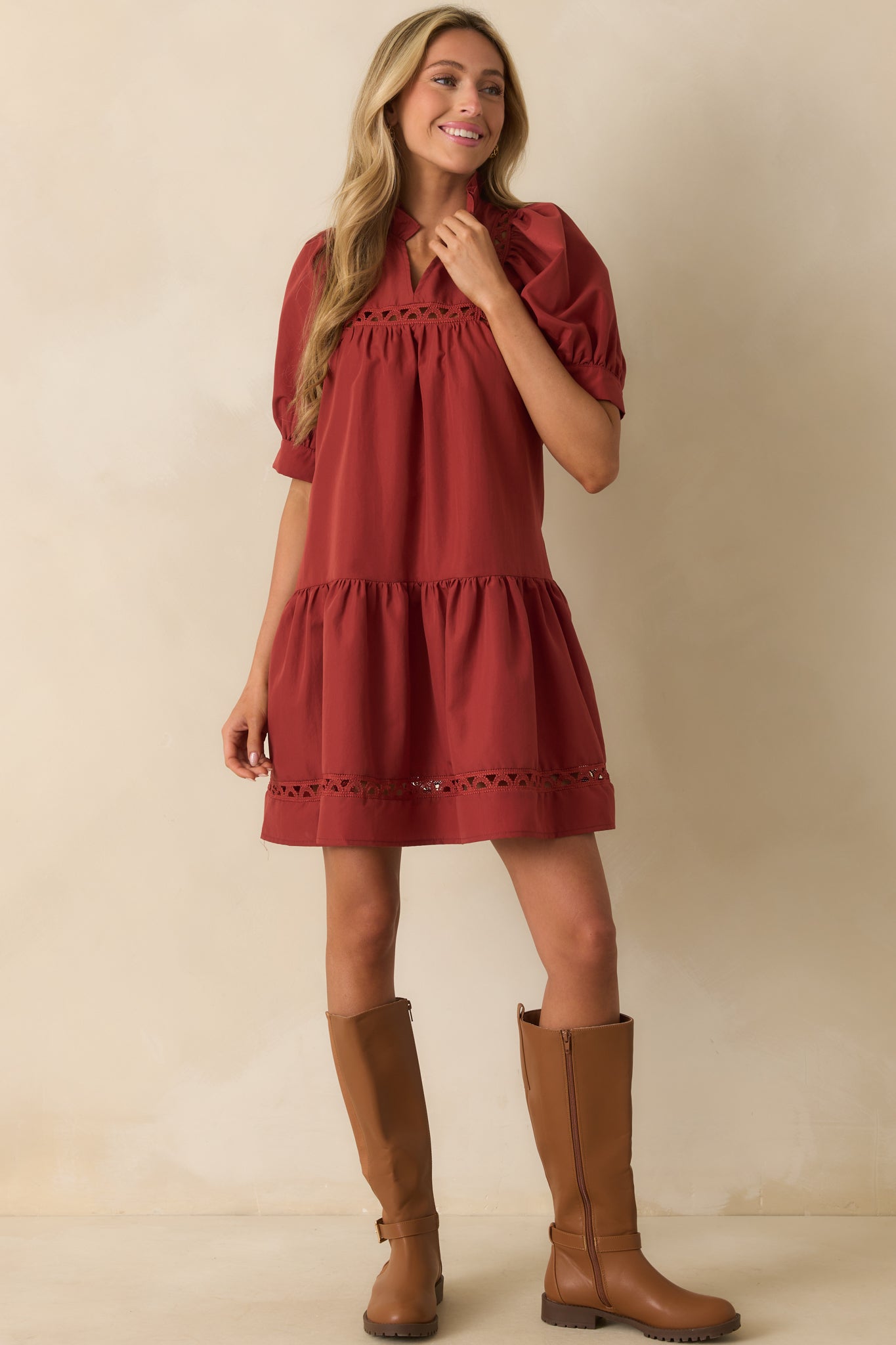 Front view of brick red dress highlighting tiered hem and puff sleeve shape.