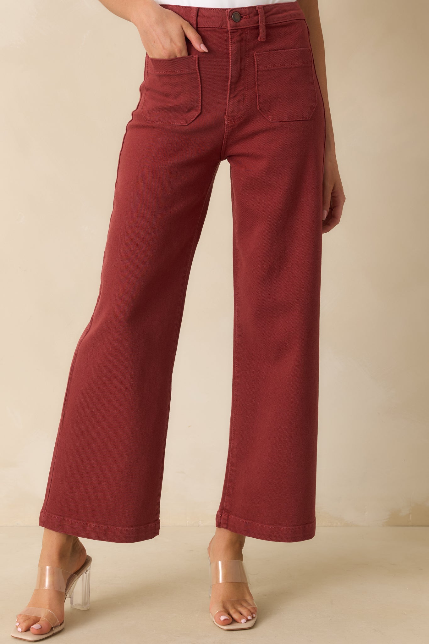 Detail of the brick red denim fabric and front patch pockets.
