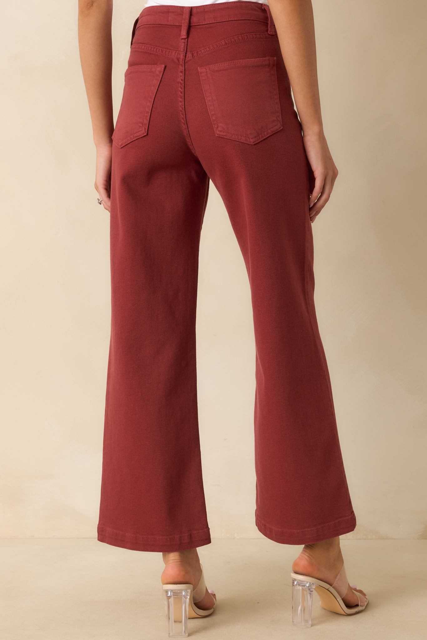 Rear view of the brick red wide-leg jeans with functional back patch pockets and relaxed fit.