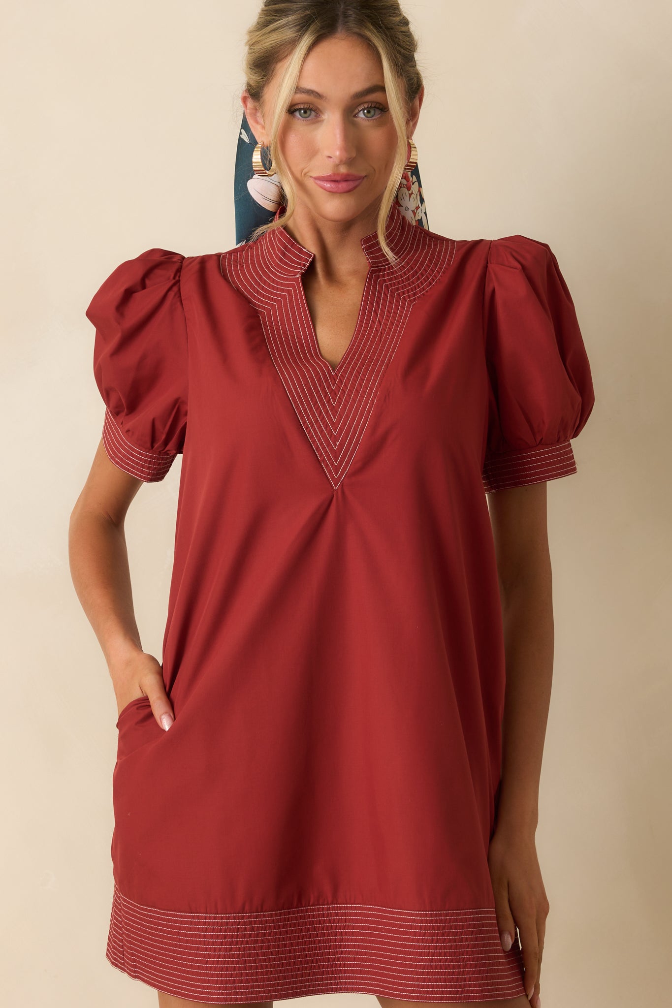 Brick red mini dress focusing on the puff sleeve and neckline design.