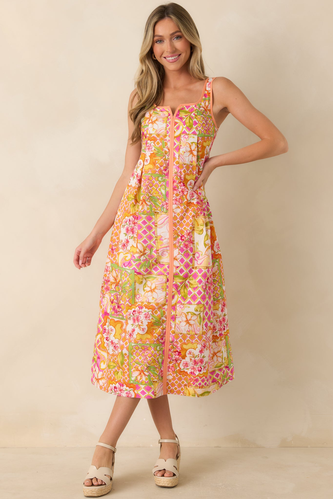 Brightly patterned midi dress with a square neckline, colorful floral patchwork print, and a graceful A-line fit that falls below the knee.