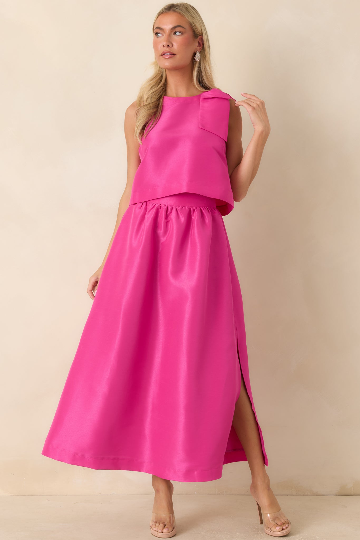 Bright pink woven top showcasing a structured fabric, sleeveless design, and polished high neckline.