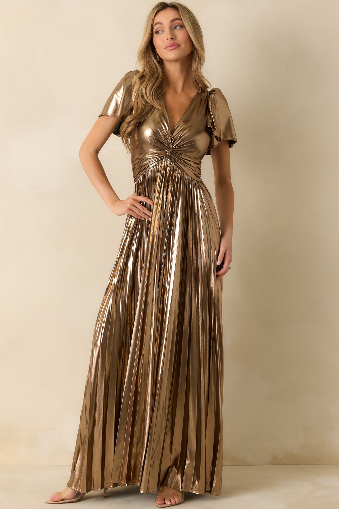 Shiny bronze metallic maxi dress with a twisted V-neck, flutter short sleeves, and pleated A-line skirt for an elegant drape.