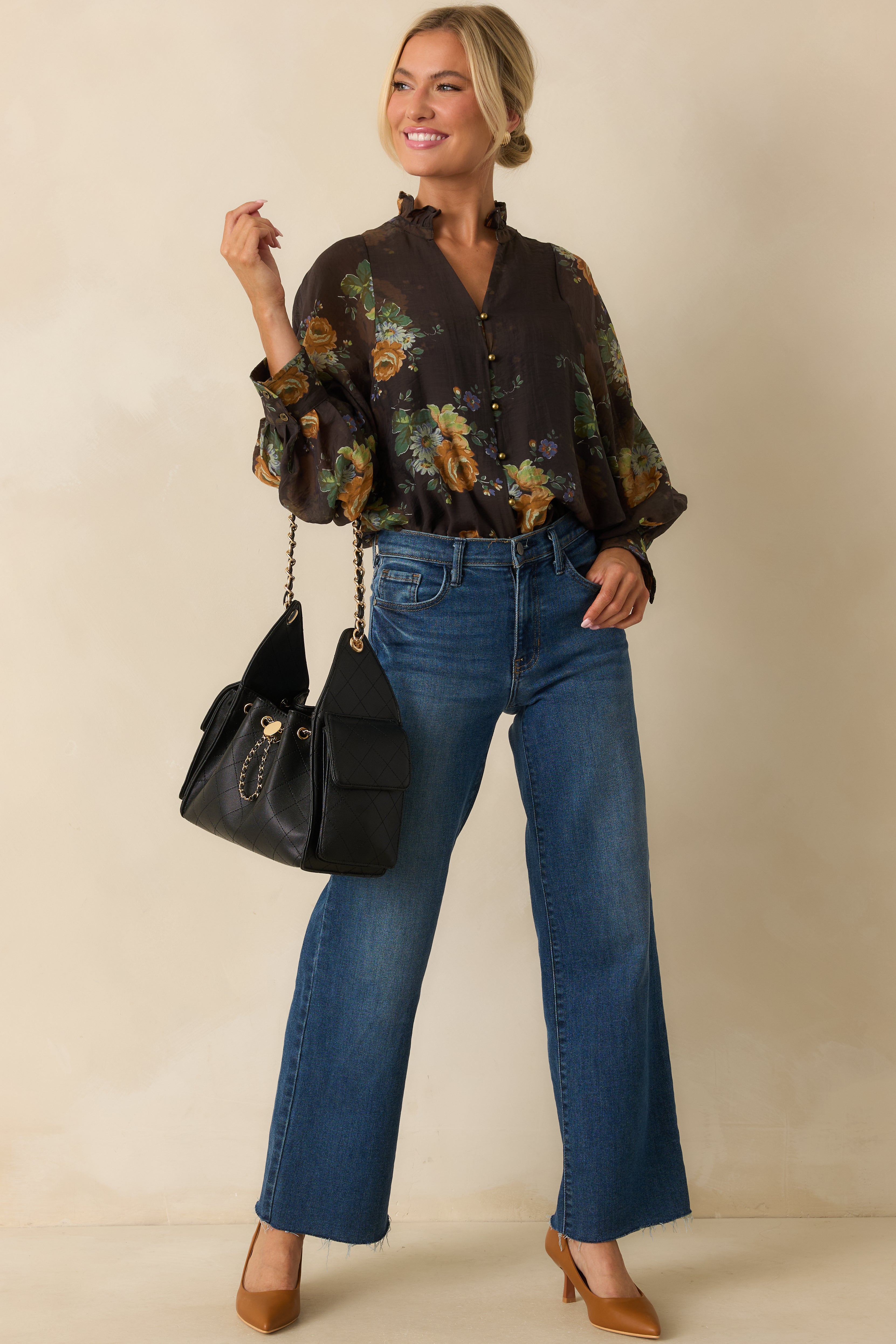 Front view of brown blouse featuring vibrant multicolor floral print and ruffled neckline.