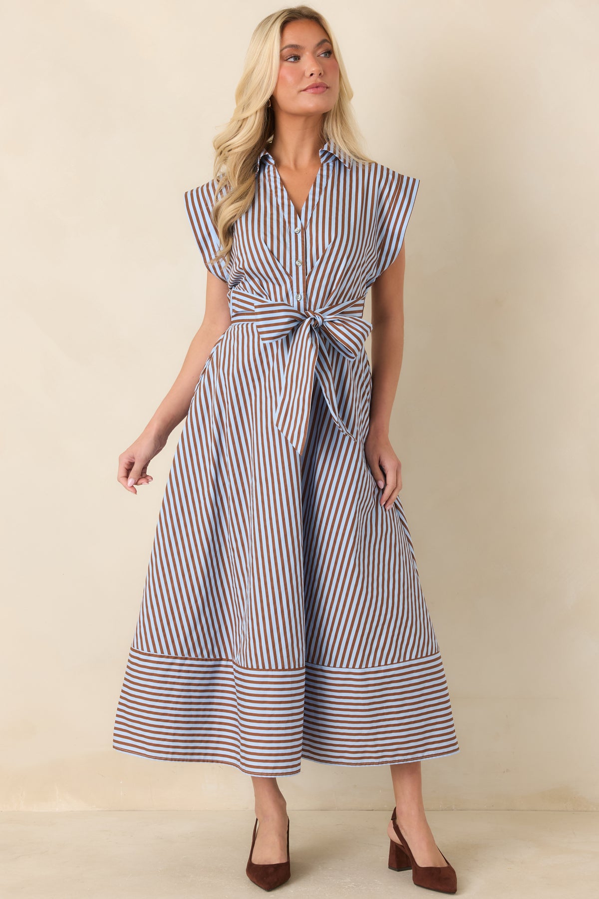Brown and blue cotton dress featuring a partial button placket, fitted back waistband, and flowing midi skirt.