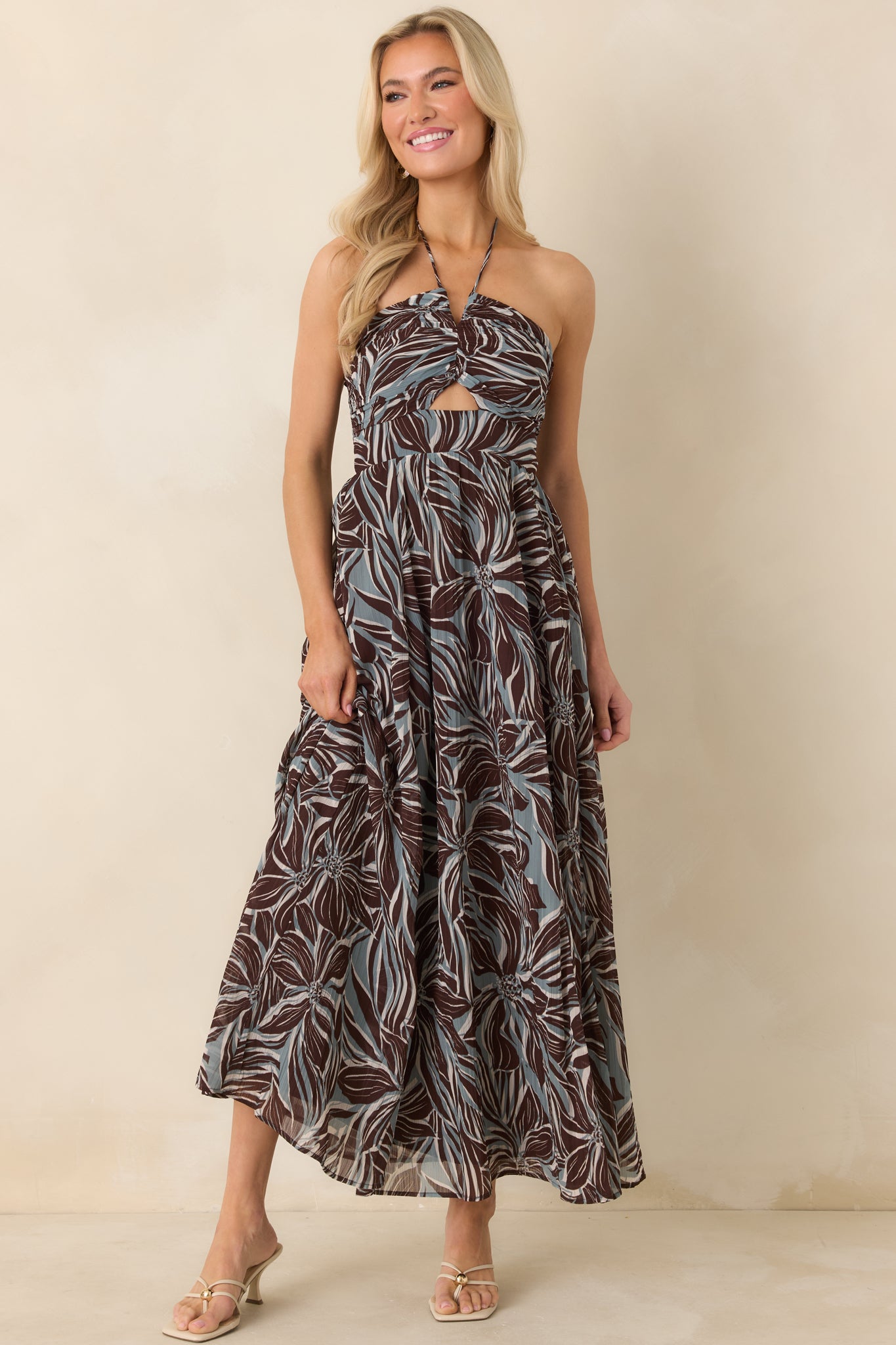 Brown and blue floral dress highlighting adjustable halter straps, keyhole detail, and flowing silhouette.