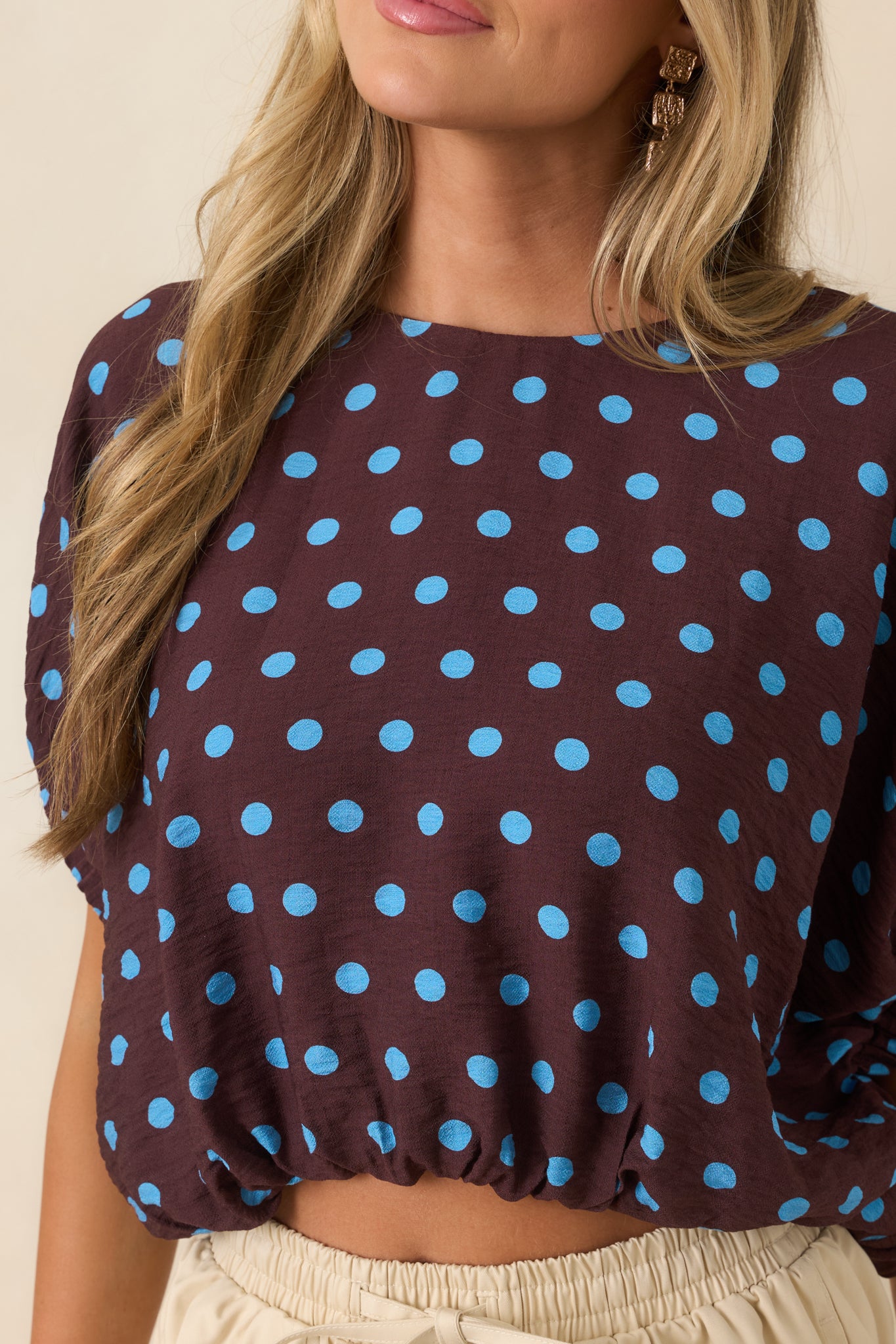 Close-up view of the brown and blue polka dot top highlighting the fabric texture and sleeve detailing.