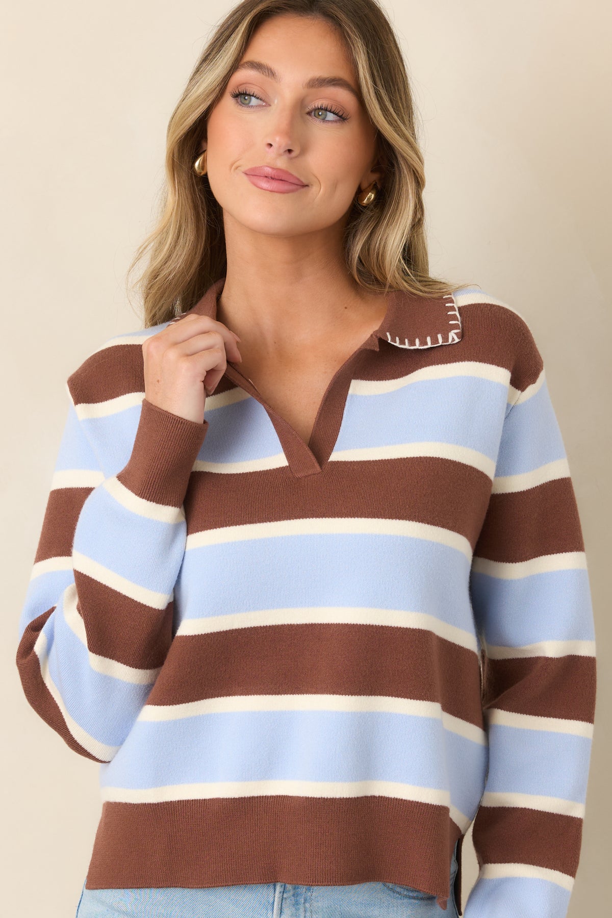 Color-blocked sweater featuring bold horizontal stripes and a contrasting brown pointed collar with intricate decorative stitching.