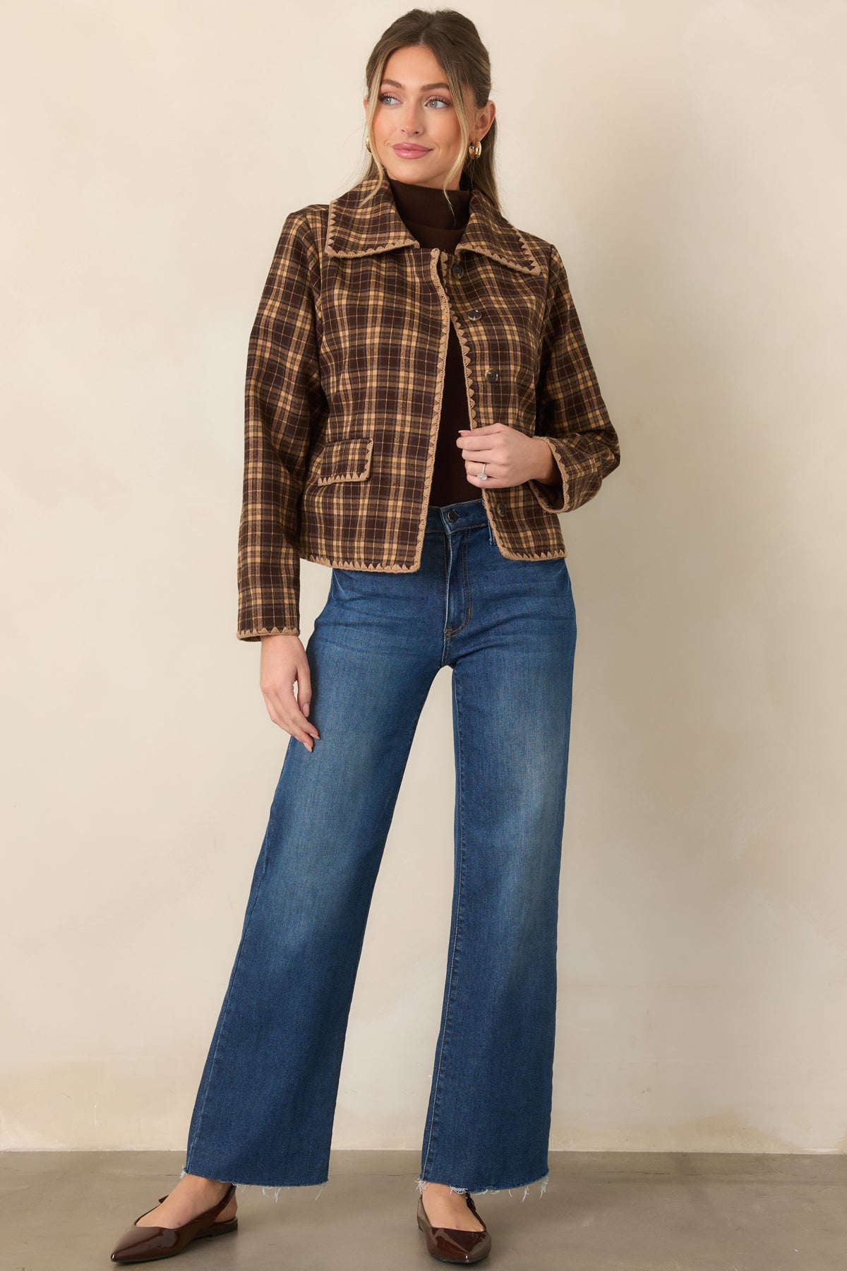 Structured plaid jacket in warm brown and camel tones with a button-front closure, contrast stitching, and slightly cropped silhouette.
