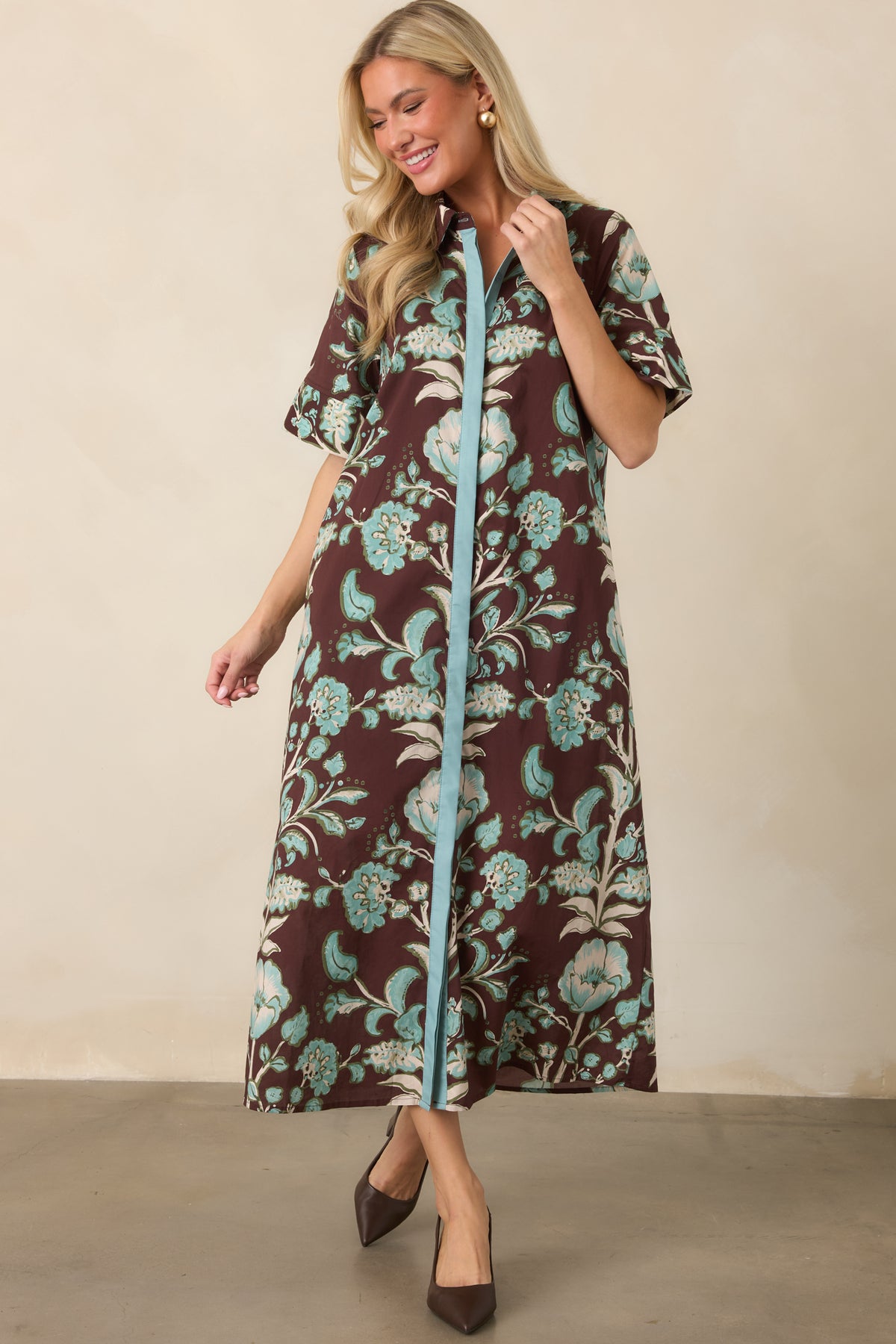 Rich brown cotton dress features an allover aqua and ivory botanical pattern with short sleeves and a relaxed silhouette.