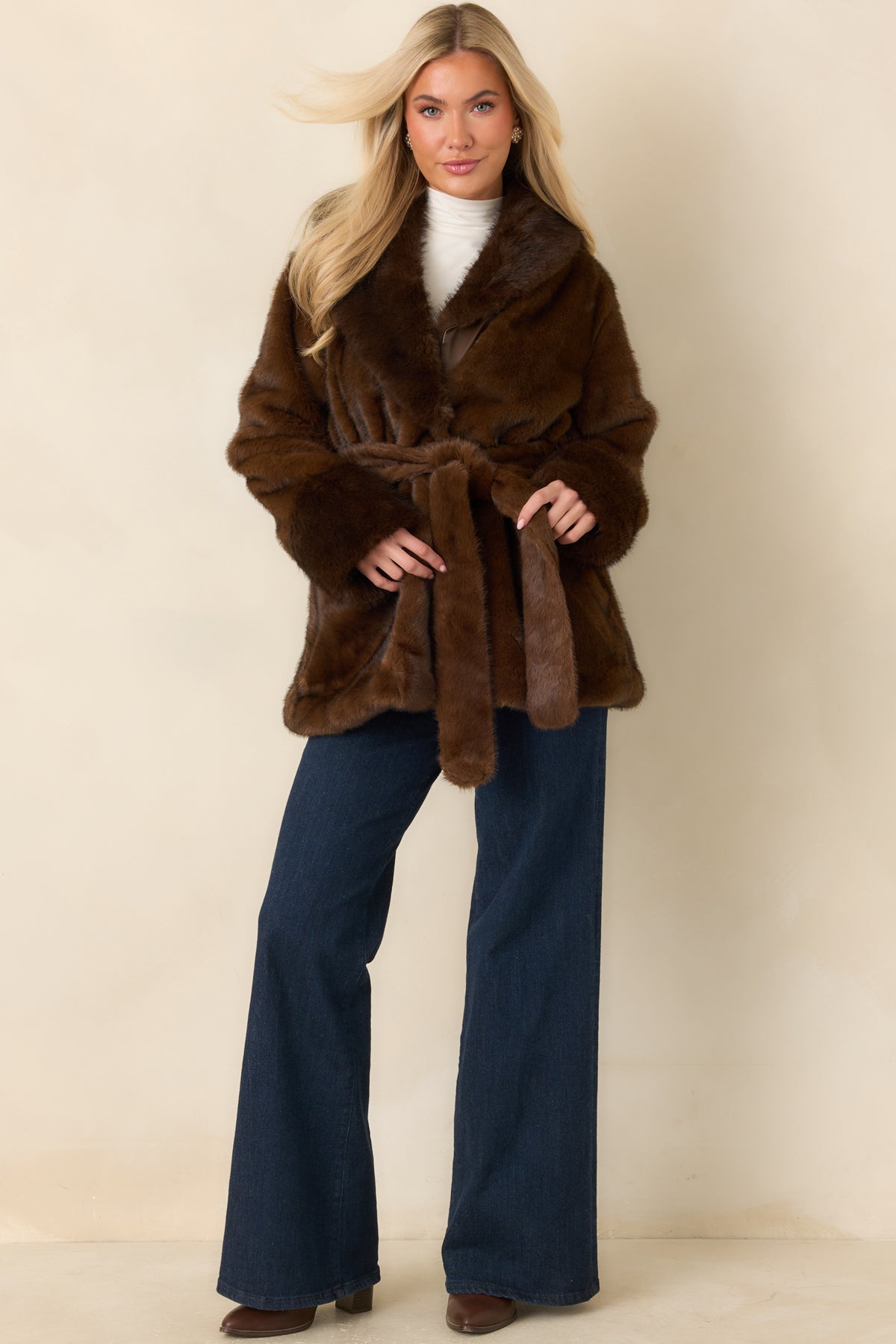 Soft brown faux fur coat with a belted waist, oversized collar, and voluminous sleeves.