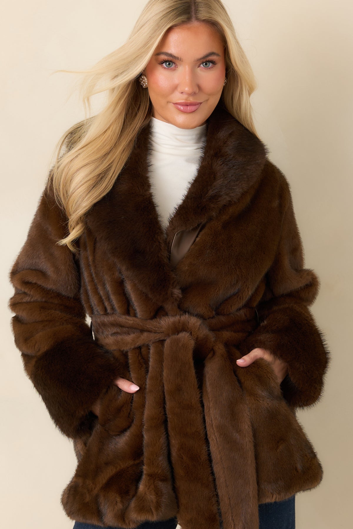 Brown faux fur coat highlighting the oversized notched lapels and plush texture around the neckline.