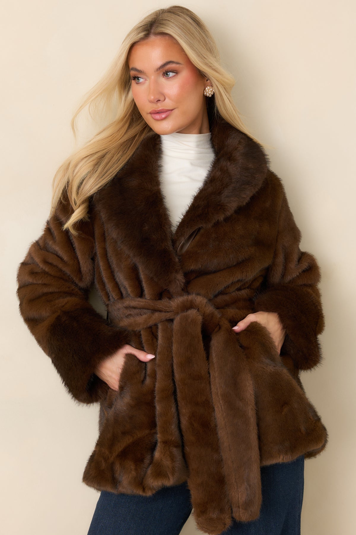Plush brown faux fur coat with long sleeves finished by wide statement cuffs.