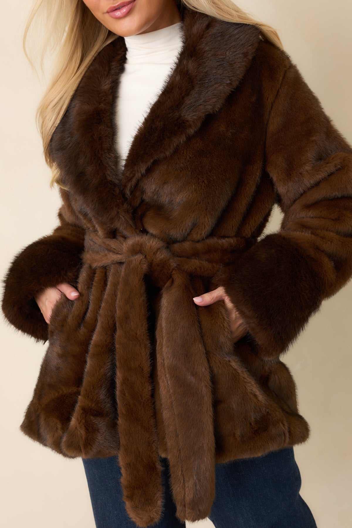 Close detail of the brown coat’s ultra-soft faux fur texture and oversized notched lapel.