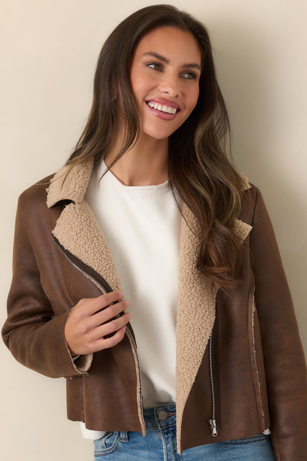 Beige sherpa collar and wide notched lapels on the distressed brown faux leather jacket.