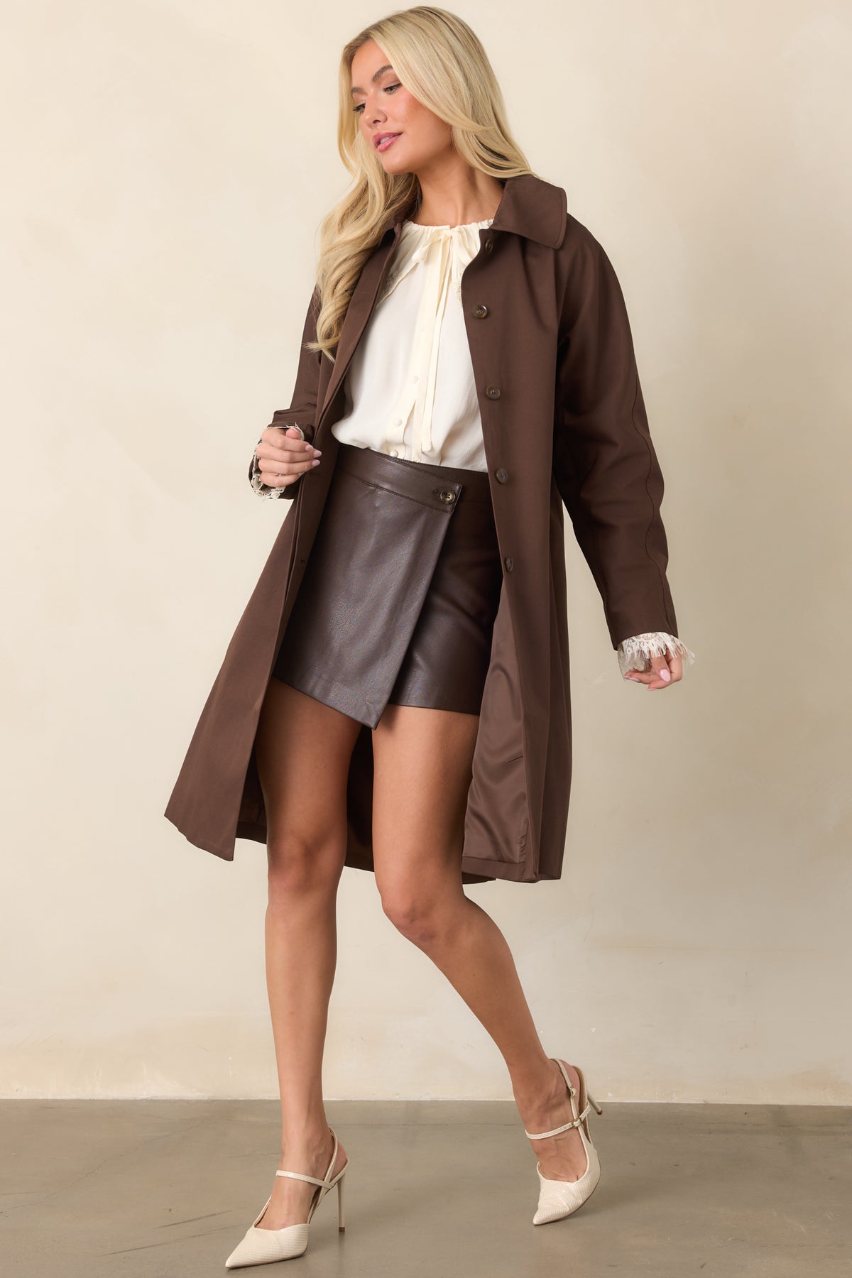 Brown faux leather mini skort showcasing its layered wrap front and clean waistband.