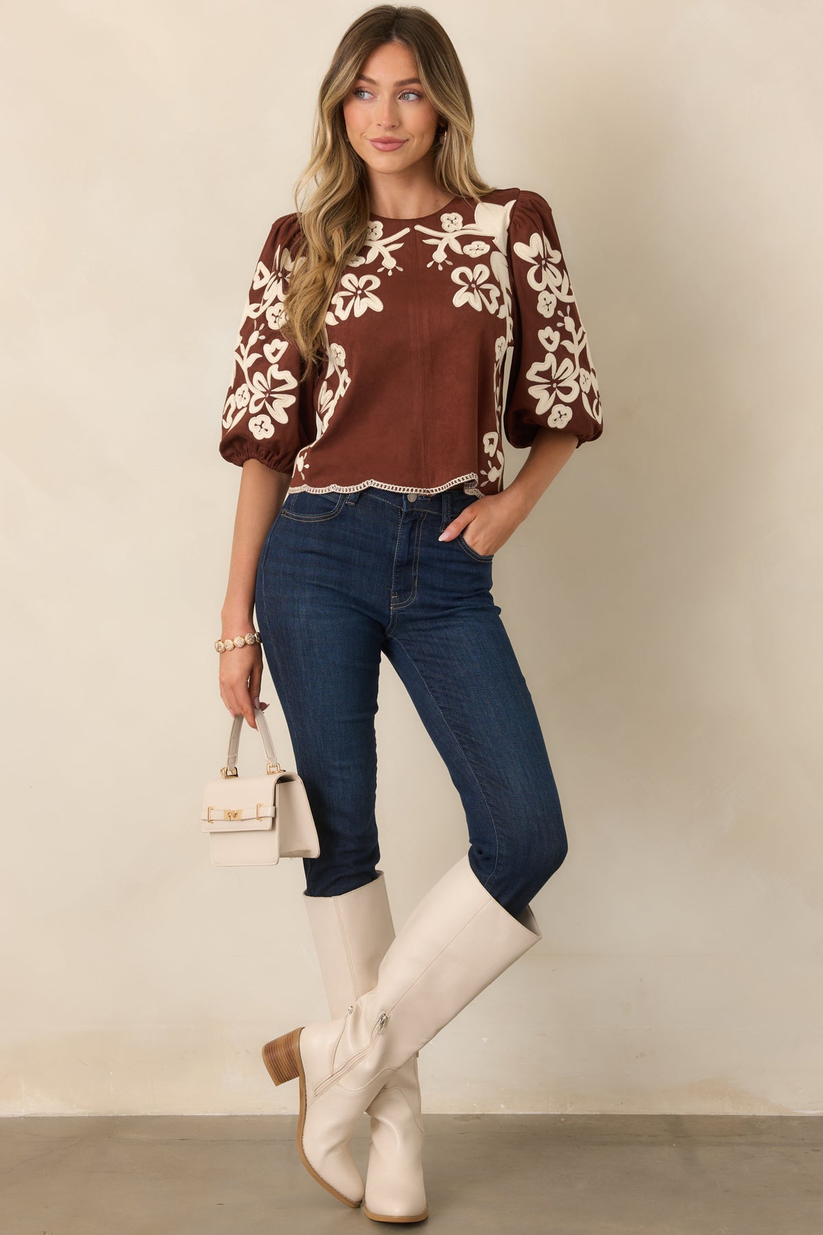 Relaxed brown faux suede top with embroidered floral detailing and contrast stitching along the scalloped hem.