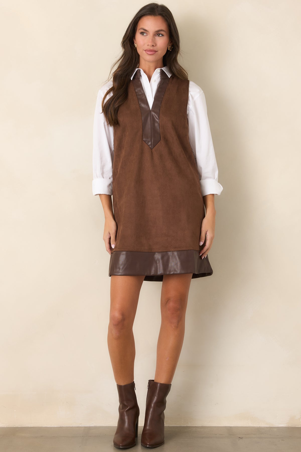 Rich brown faux suede mini dress with smooth faux leather trim along the deep V-neckline and hem.