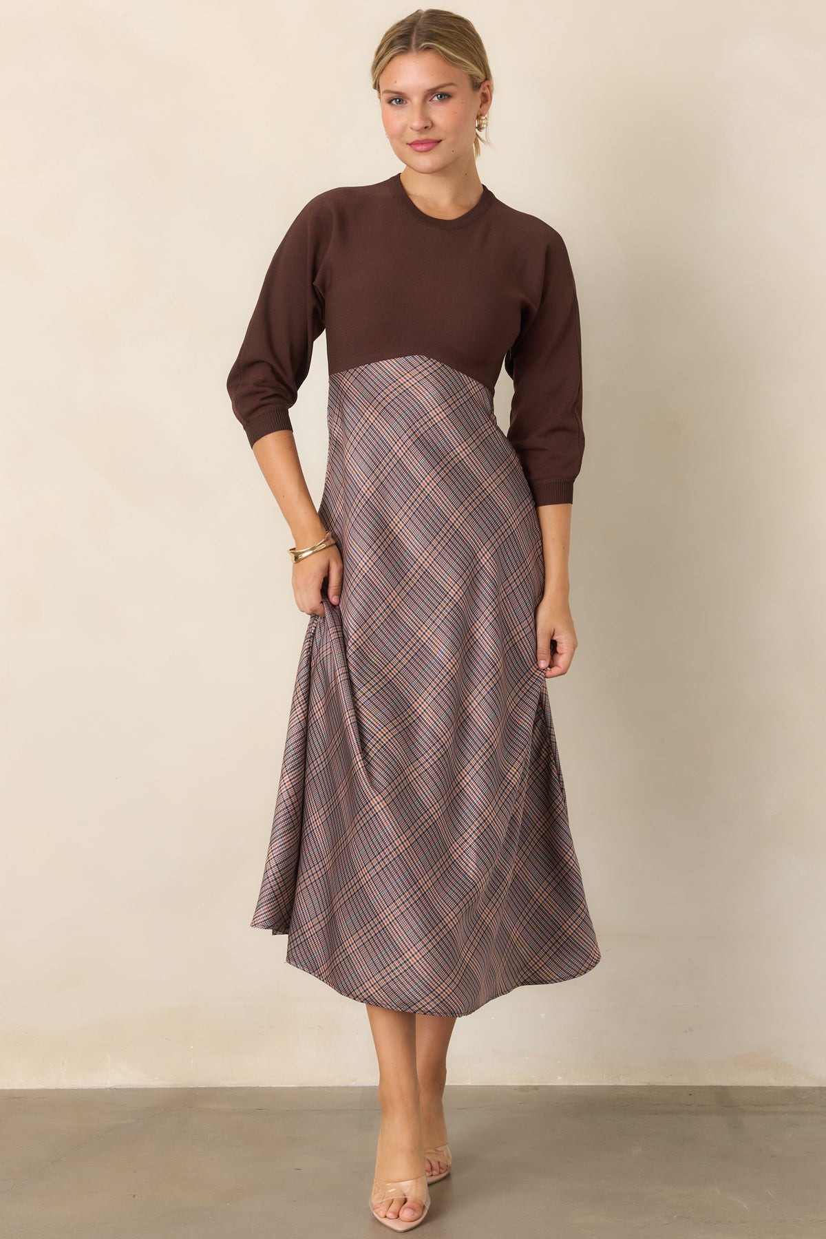 Fitted brown knit dress featuring a round neckline and three-quarter sleeves with a clean, streamlined shape.