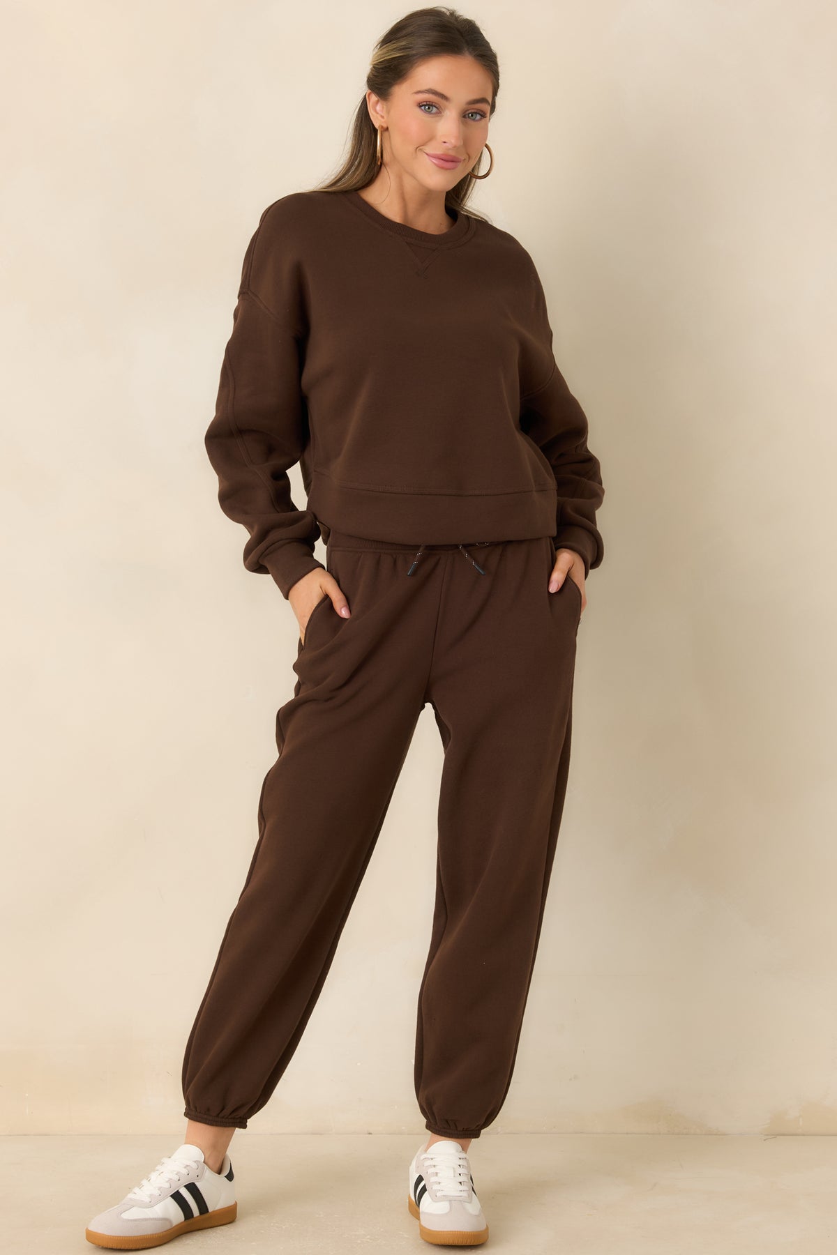 Brown cotton-blend fleece joggers with a high-rise waistband, roomy legs, and elasticized cuffs.