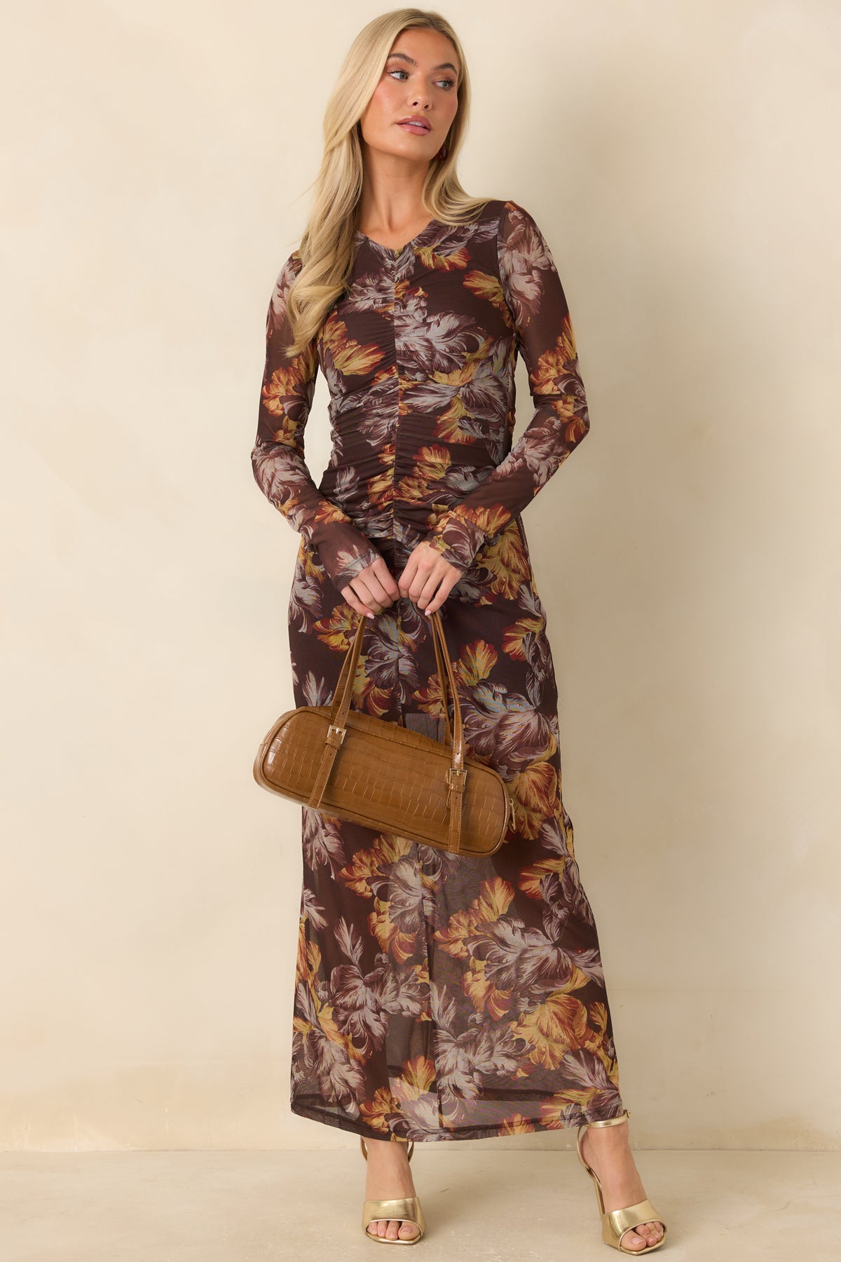 Fitted brown dress with rust and ochre blooms scattered across sheer mesh sleeves.