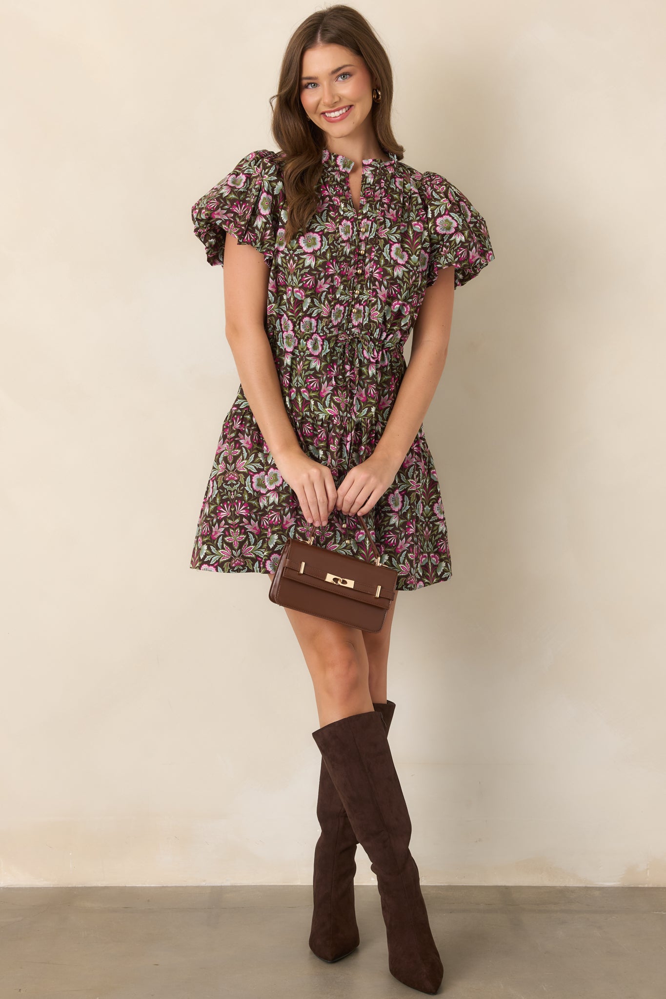 Brown floral mini dress with fuchsia, olive, and sage accents, split neckline, flutter sleeves, drawstring waist, and softly tiered skirt.