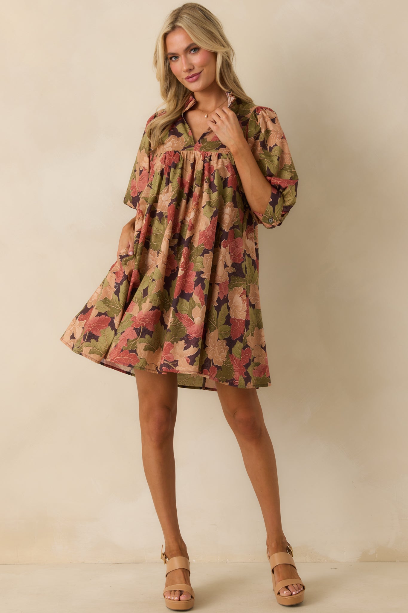 Brown floral mini dress with a split v-neckline, ruffle trim, and half-length puff sleeves.