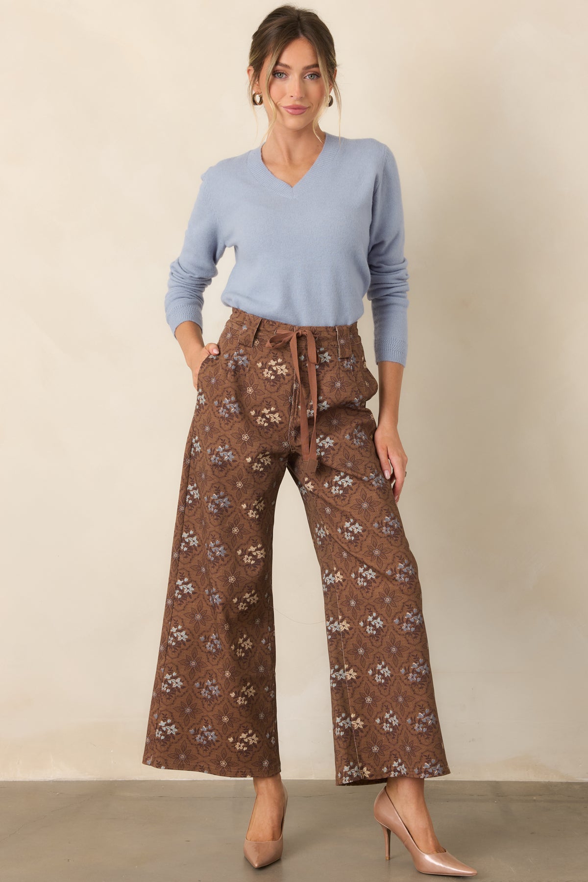 Cropped brown pants with intricate floral medallions, belt loops, and a straight wide-leg cut.