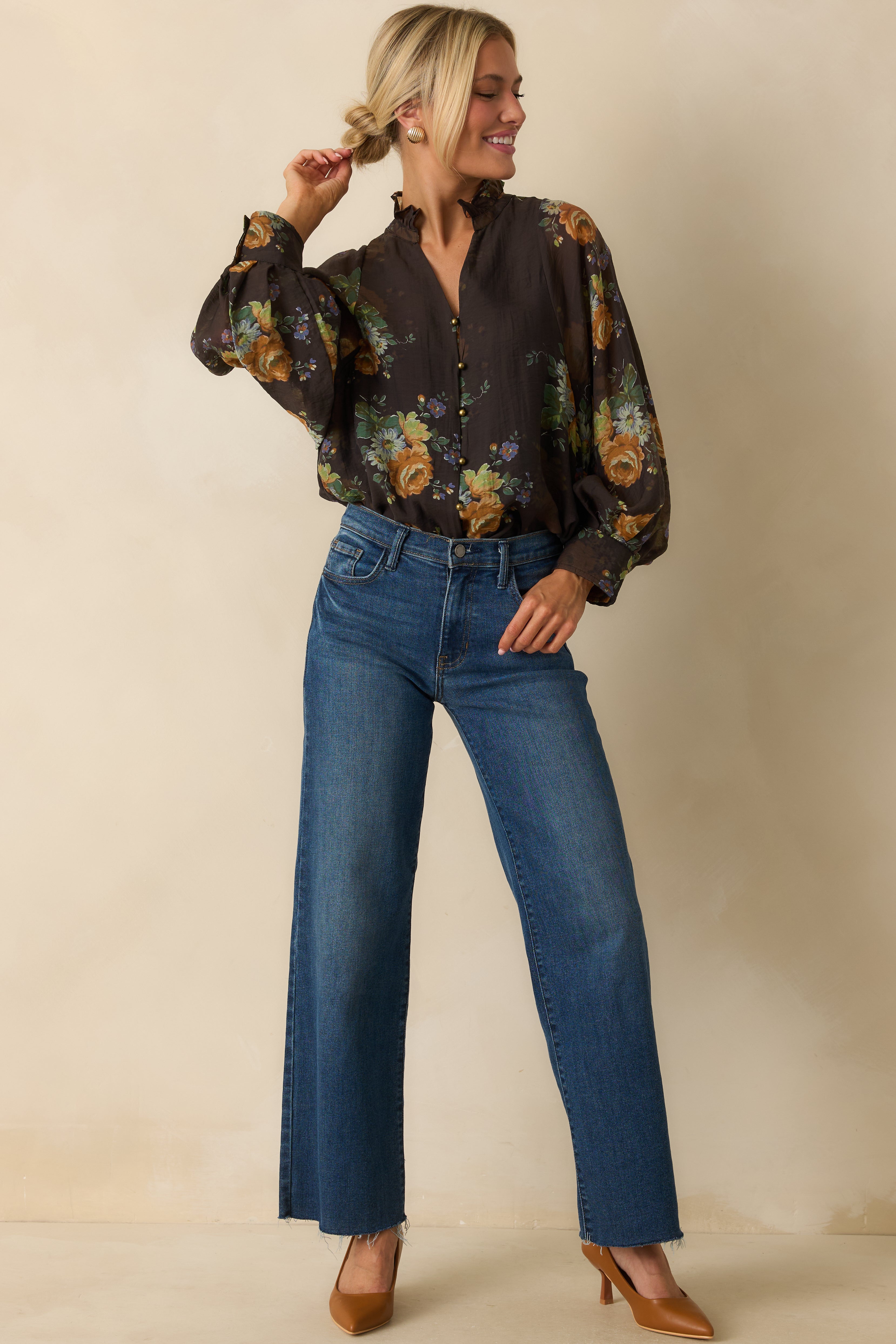 Brown blouse with multicolor floral print, ruffled neckline, and long peasant sleeves.