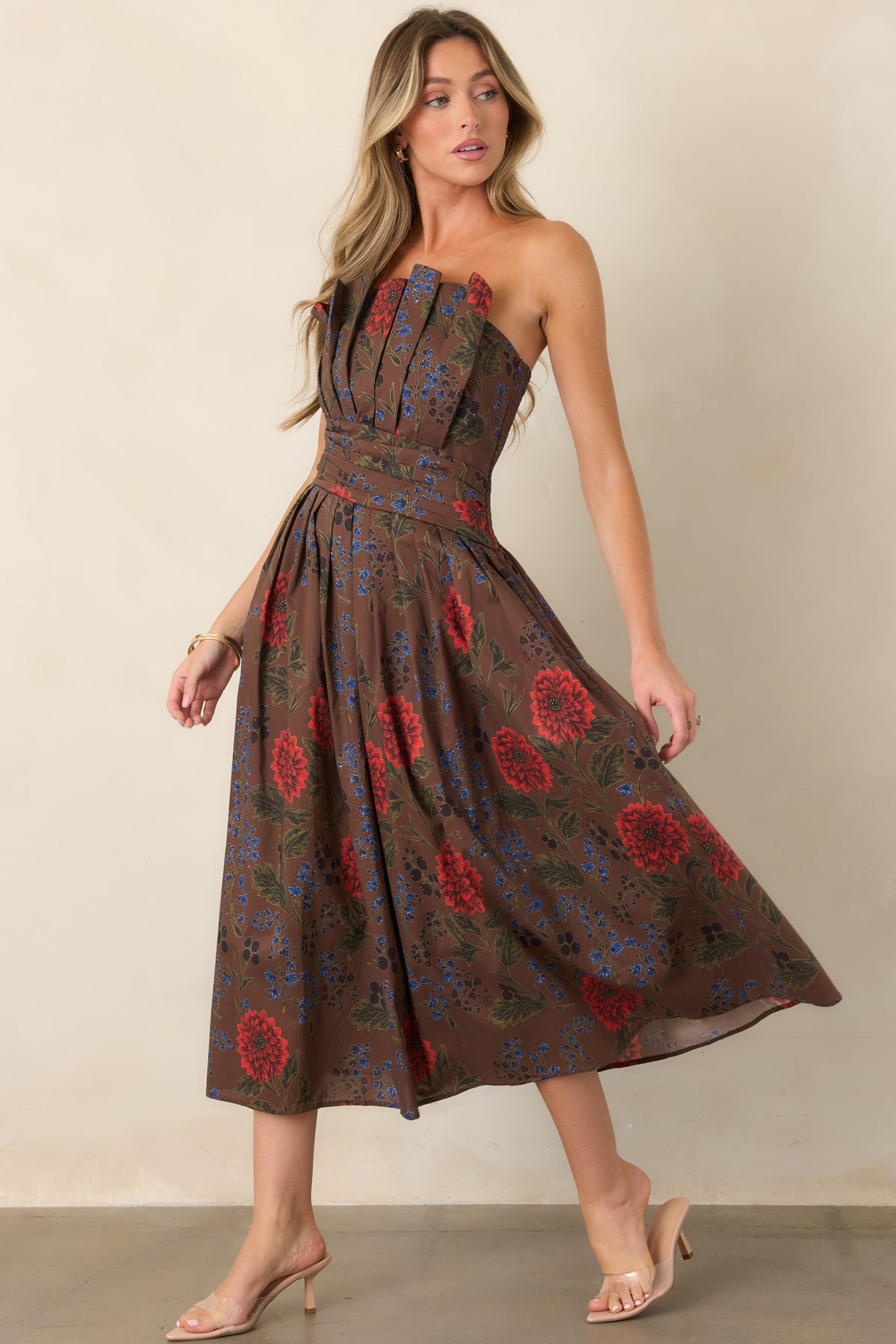 Brown floral strapless midi dress with a structured pleated bodice and voluminous midi skirt in motion.
