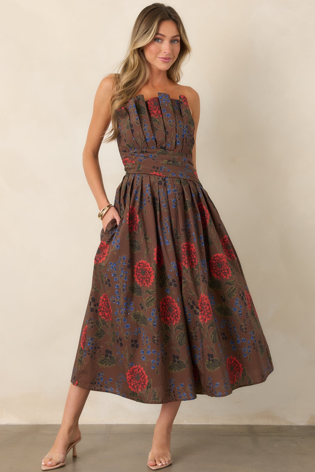 Brown floral strapless midi dress featuring a structured bodice, defined waist and pleated A-line skirt.
