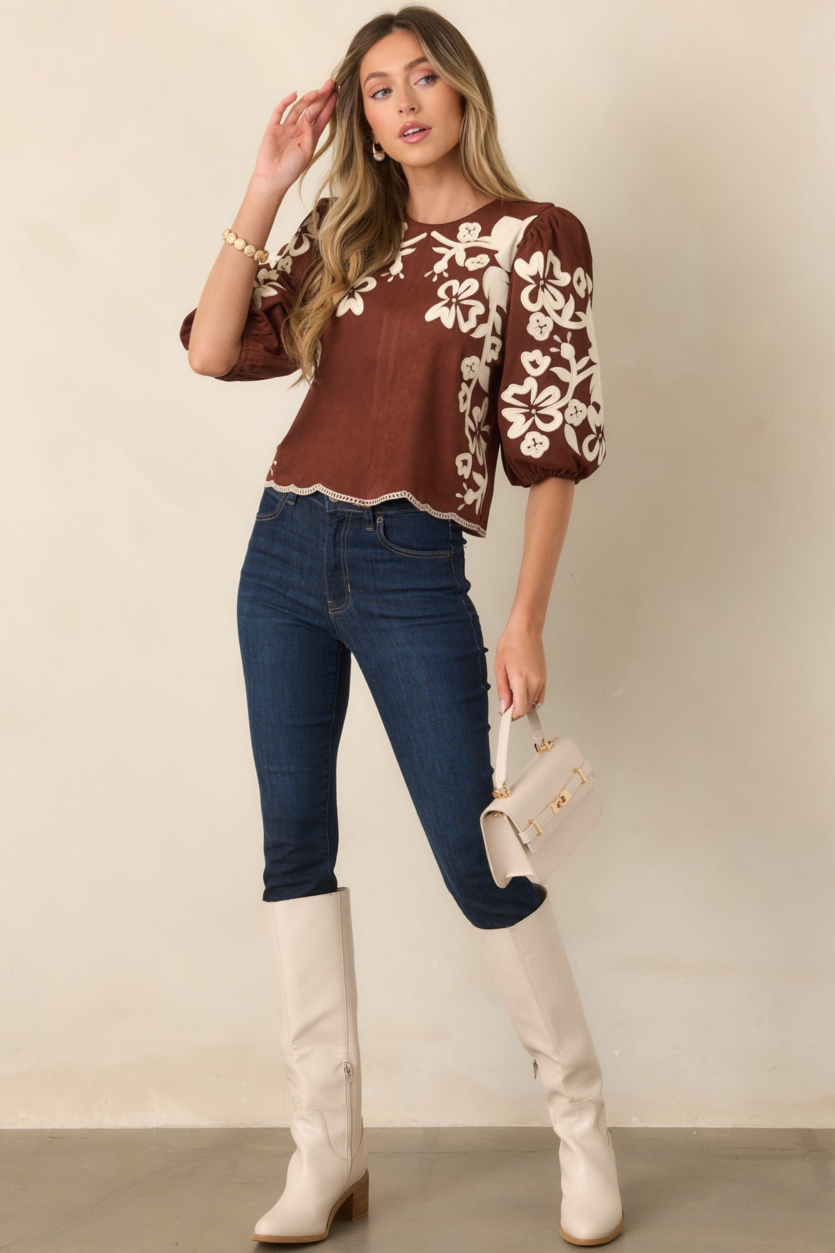Vintage-inspired brown top with ivory floral appliqués, embroidered accents, and a gently scalloped hem.