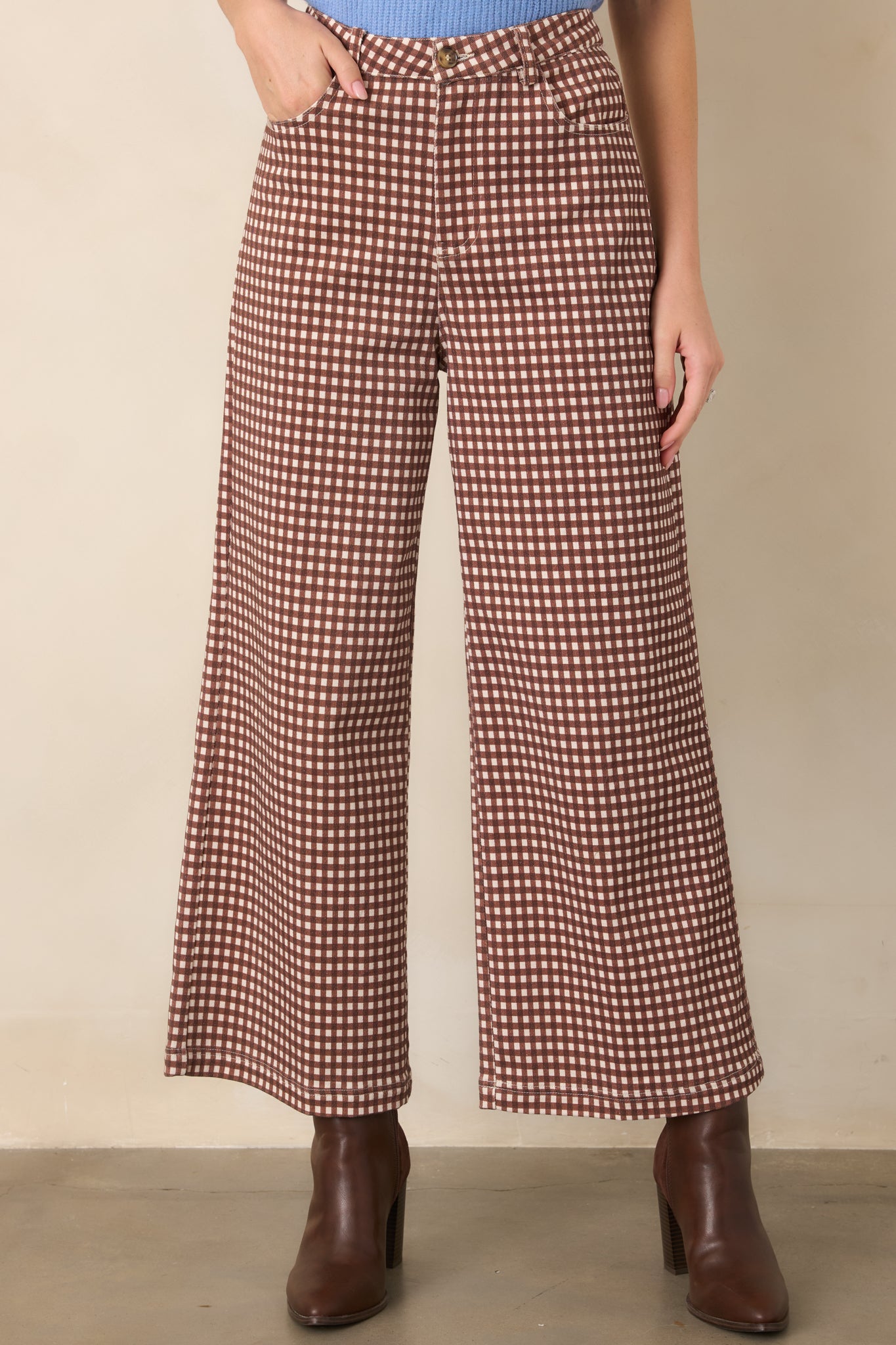 Brown and ivory checkered pants emphasizing the flowing wide-leg shape and cleanly finished hemline.