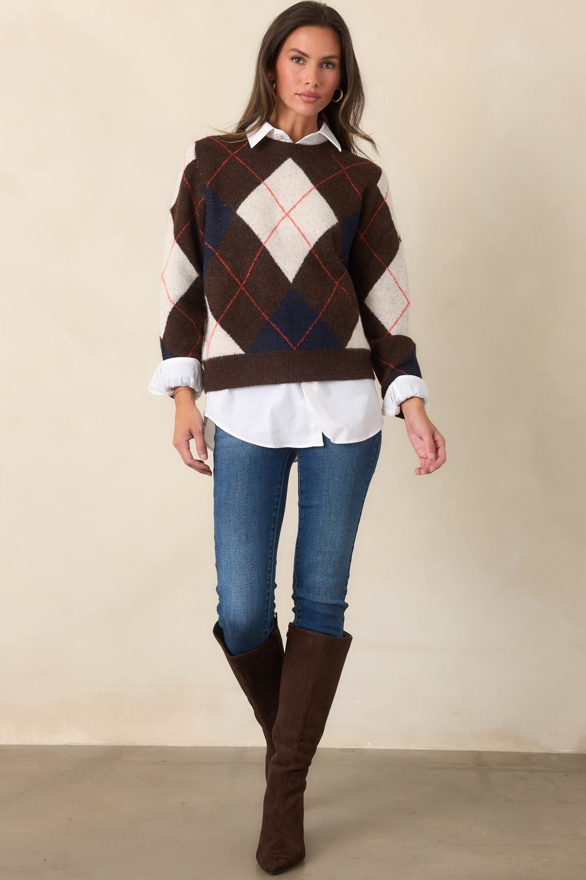 Brown knit top with ivory and navy diamond accents outlined by fine rust-red lines, finished with a relaxed fit and ribbed crew neckline.