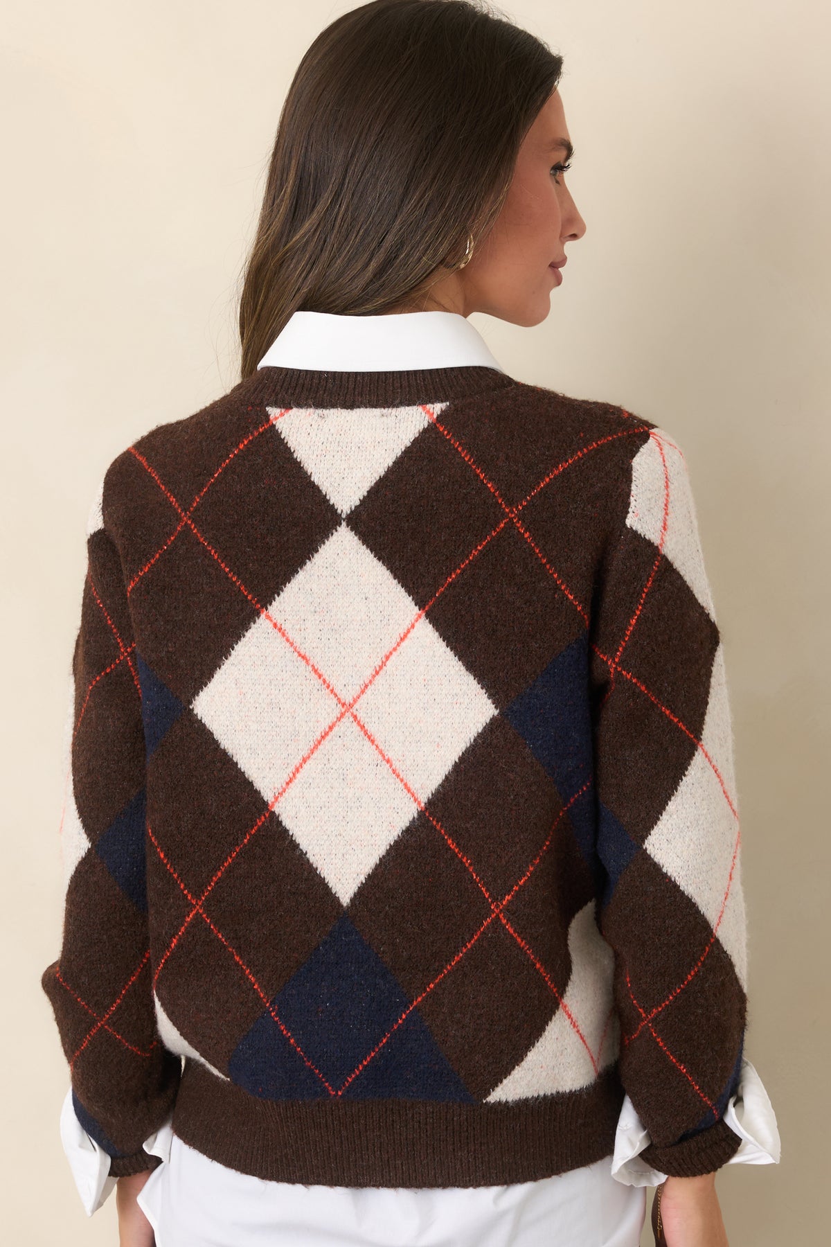 Brown knit top featuring an allover ivory and navy diamond design with rust-red accents, ribbed cuffs and hem, and a relaxed silhouette.