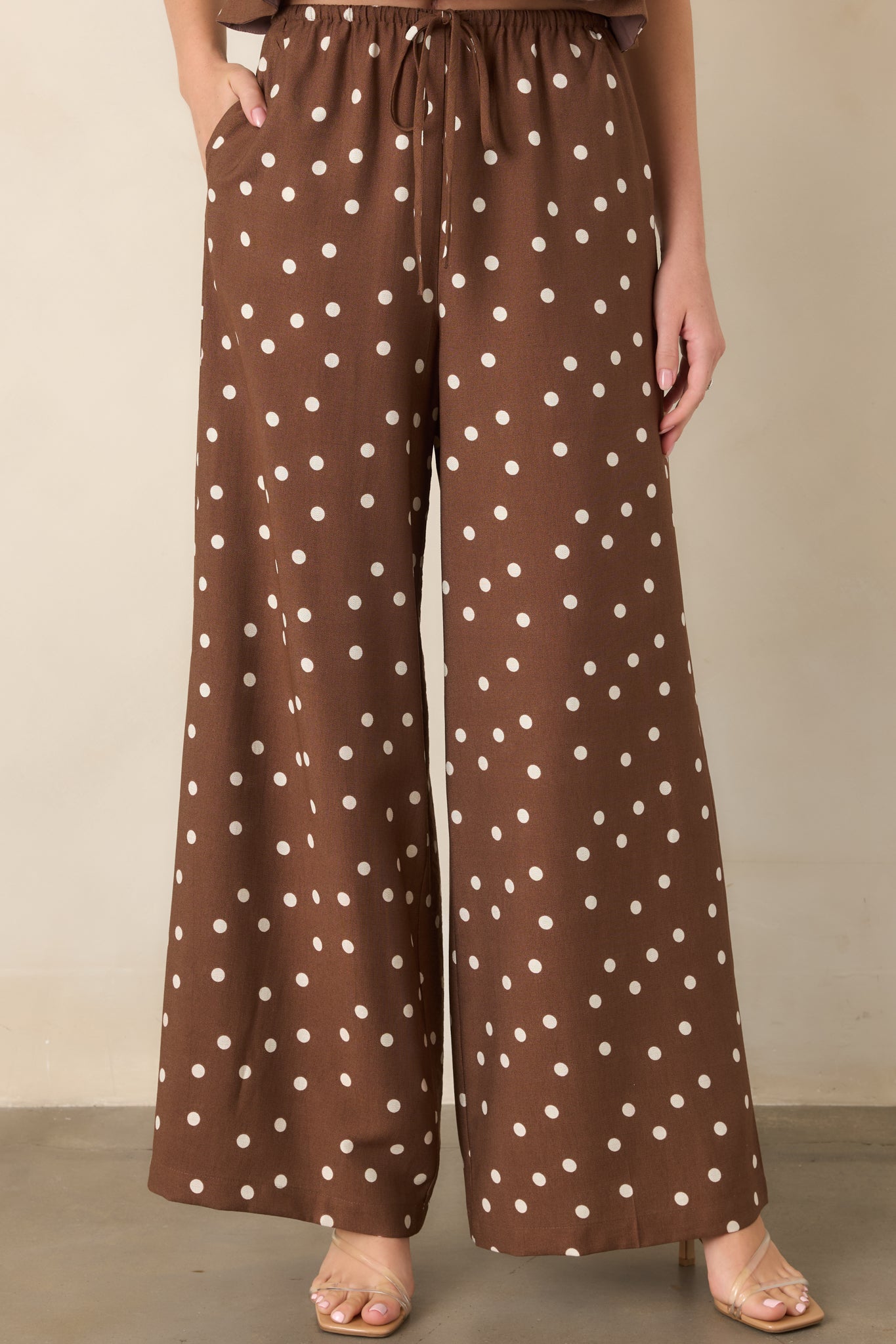Close view of the brown and ivory polka dot pants highlighting the adjustable drawstring waistband and flowing fabric.