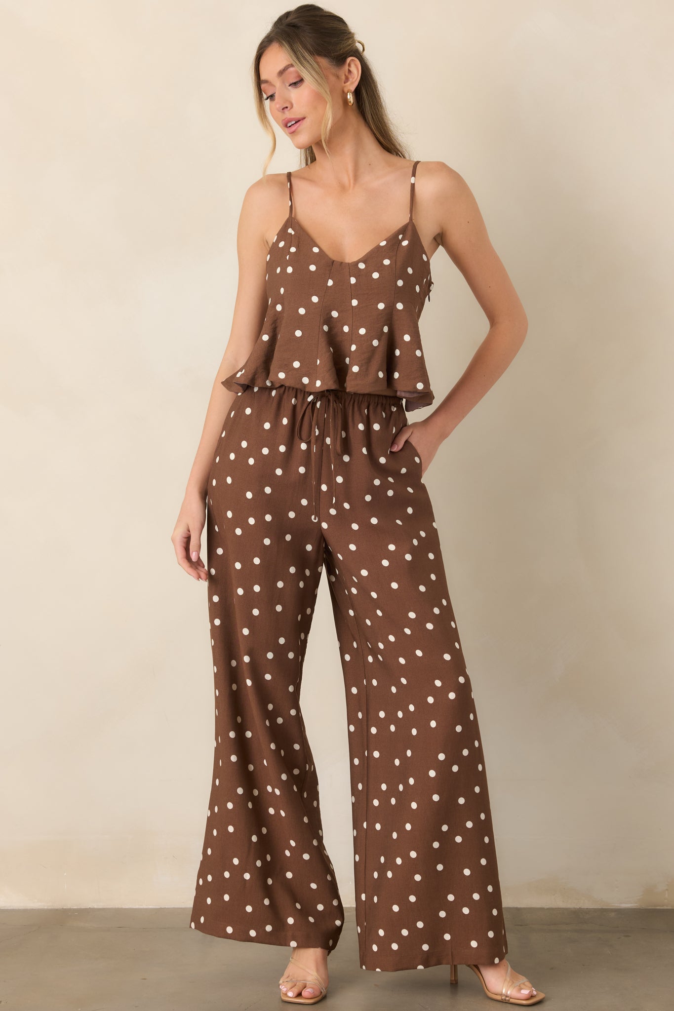 Brown and ivory spotted pants designed with a fluid wide-leg shape, relaxed fit, drawstring waist, and convenient side pockets.