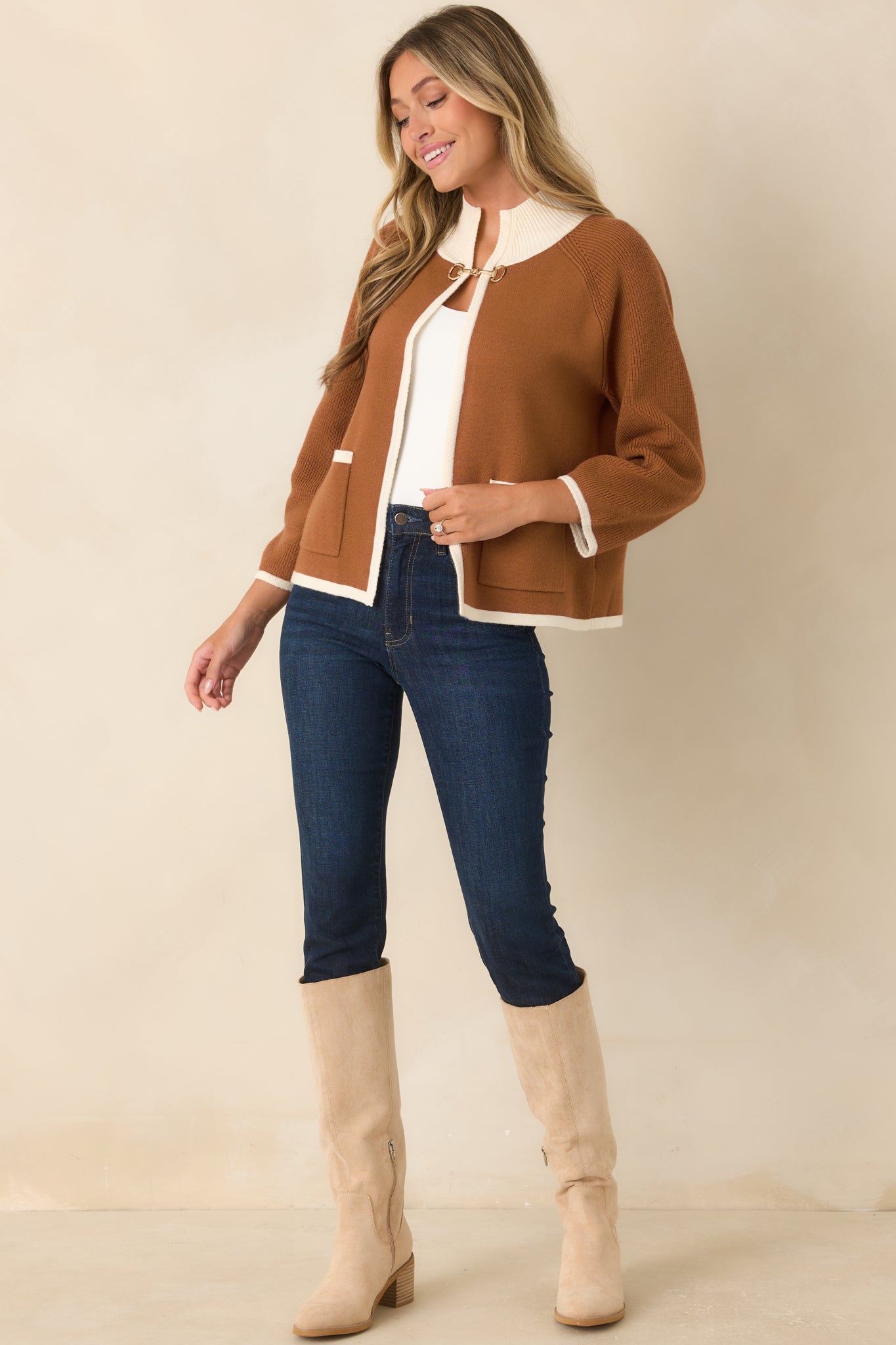 Rich brown cardigan featuring ivory contrast trim along the ribbed collar, open front, cuffs, hem, and patch pockets, finished with a gold-tone horsebit closure.