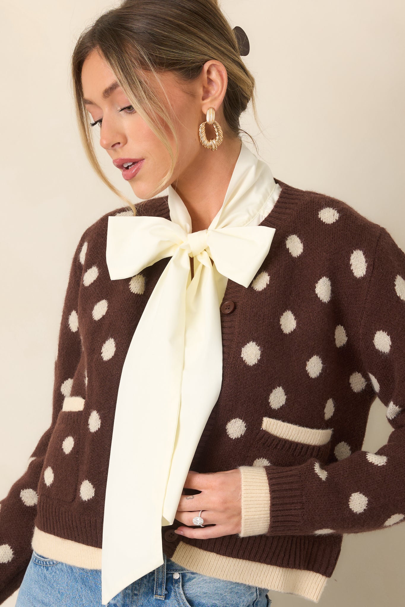 Ivory polka dots stand out against the soft brown knit, complemented by a button front and layered trim.